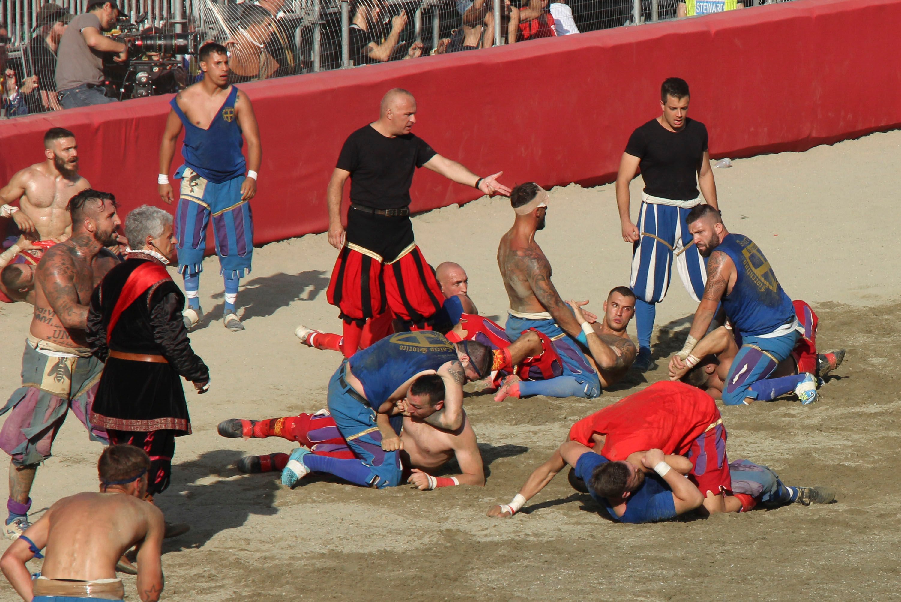 The Rossi of Santa Maria Novella (in red) take on Santa Croce’s Azzuri (in blue) watched by referees (in black) in the 2023 Calcio Storico Fiorentino, in Florence, Italy, Combining the sports of football, rugby, wrestling and street fighting, the event is one of the world’s most violent sports. Photo: John Brunton