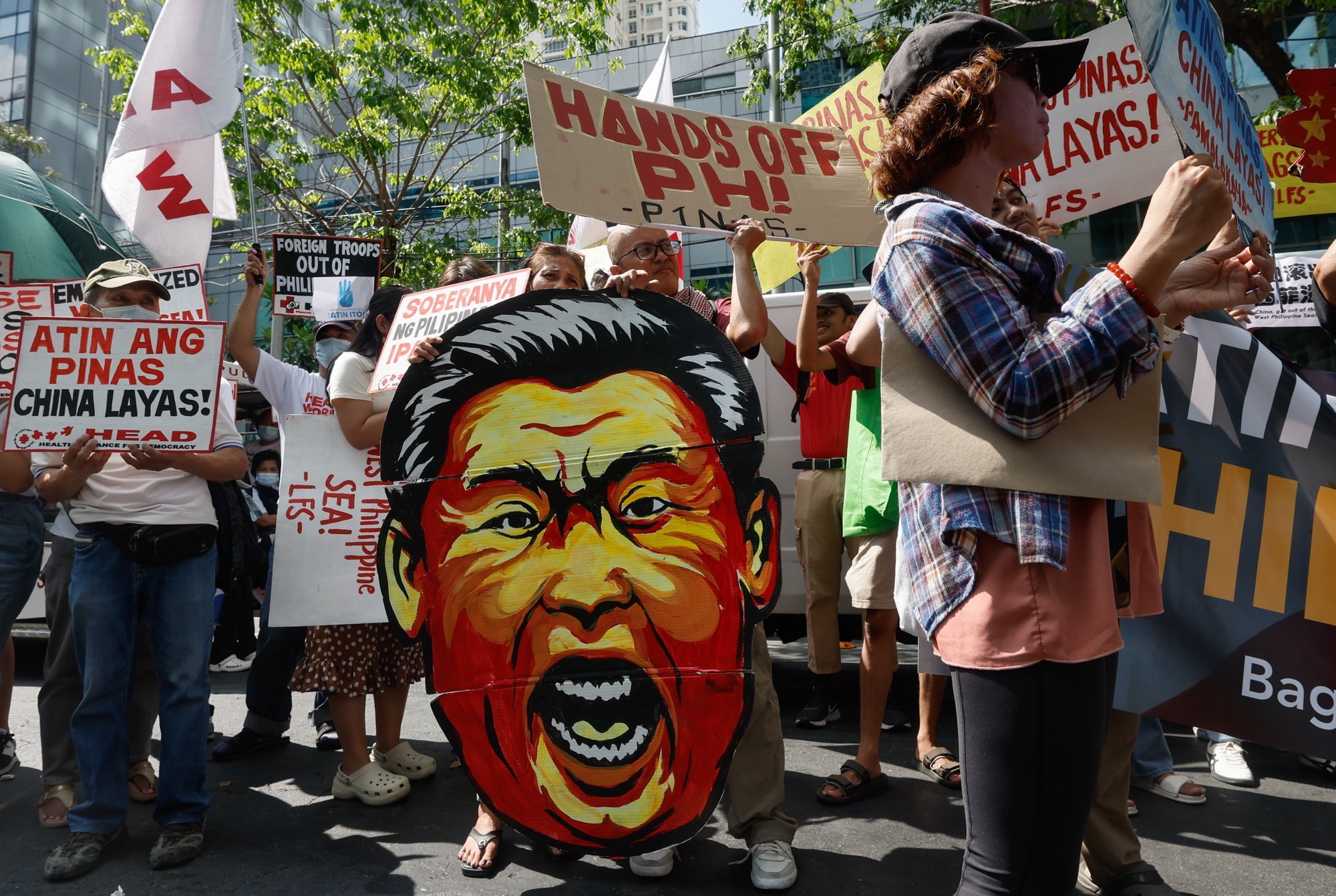 Protesters hold signs and display a caricature of Chinese President Xi Jinping during a rally outside the Chinese consular office in Makati City, Metro Manila, the Philippines, on Tuesday. Photo: EPA-EFE