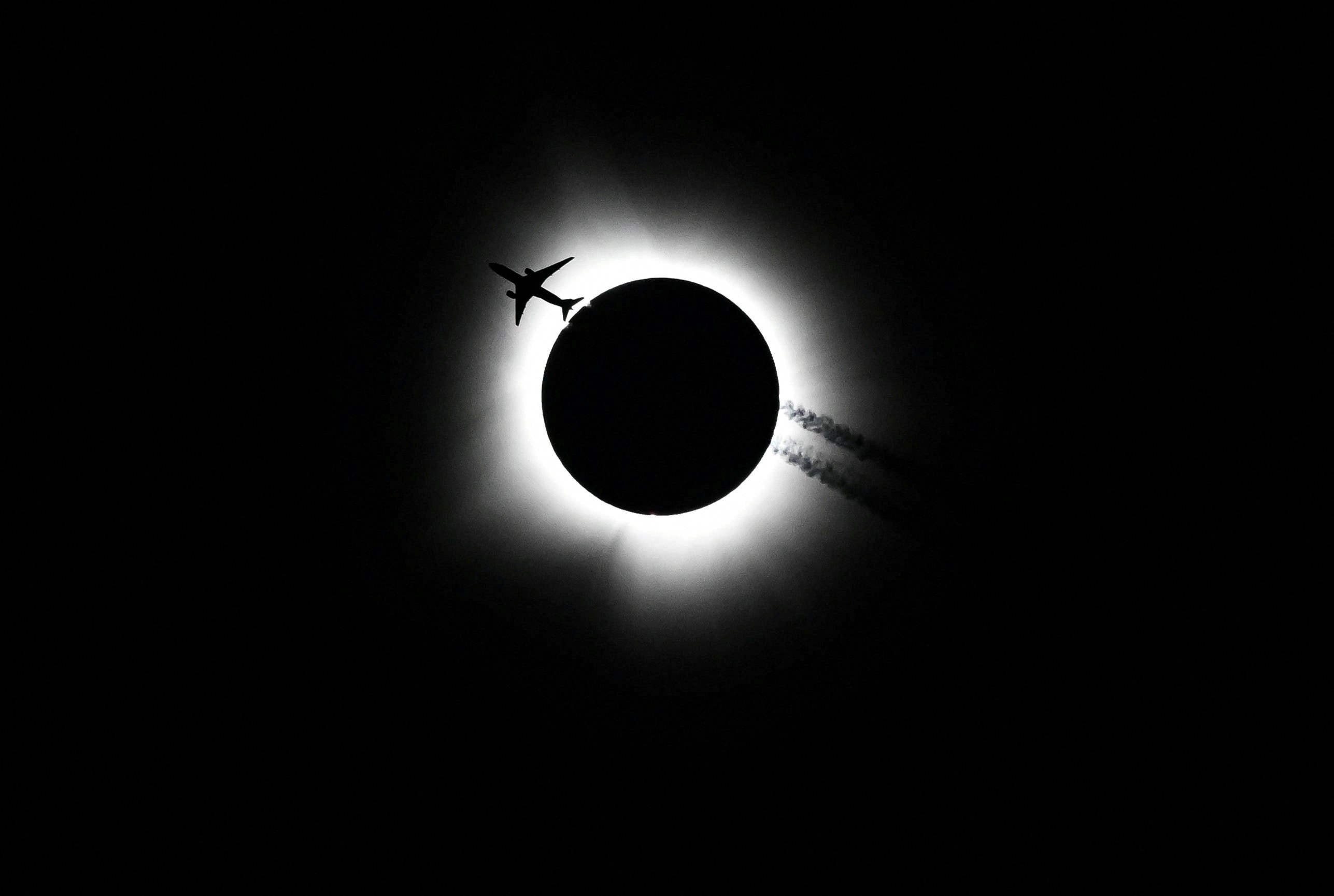 A plane passes near the total solar eclipse over Bloomington, Indiana. Photo: Bobby Goddin/USA Today Network via Reuters