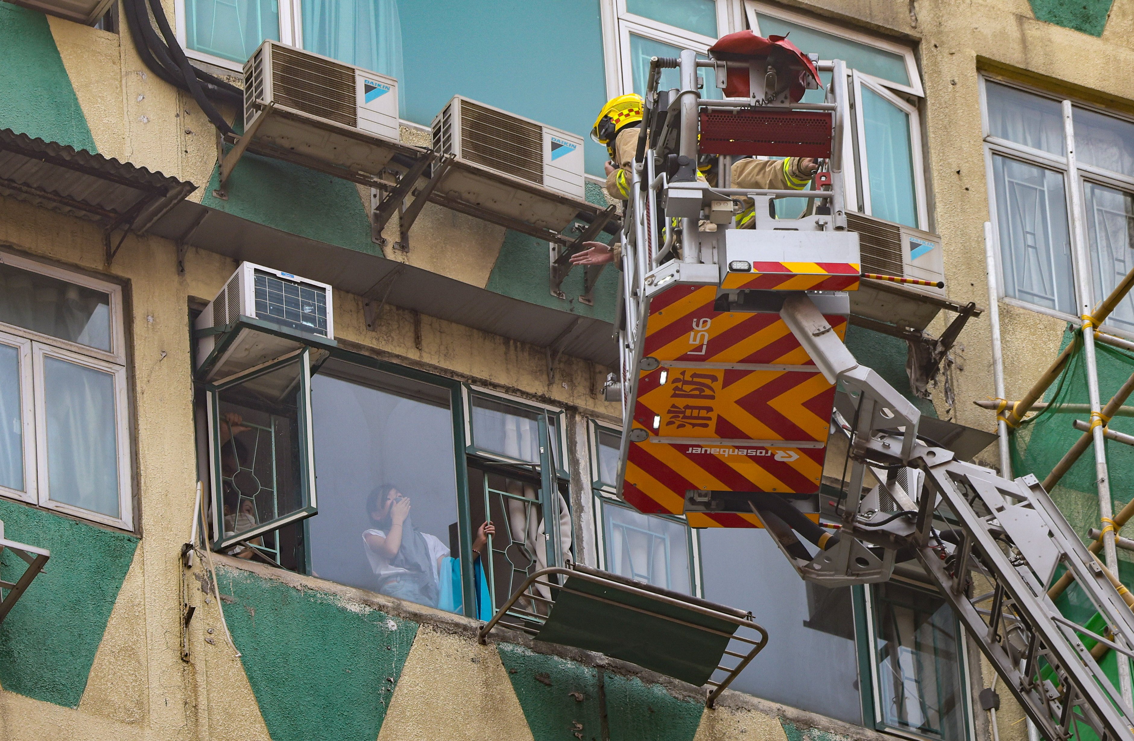 Firefighters stage a rescue using a fire engine’s ladder. Photo: Jelly Tse