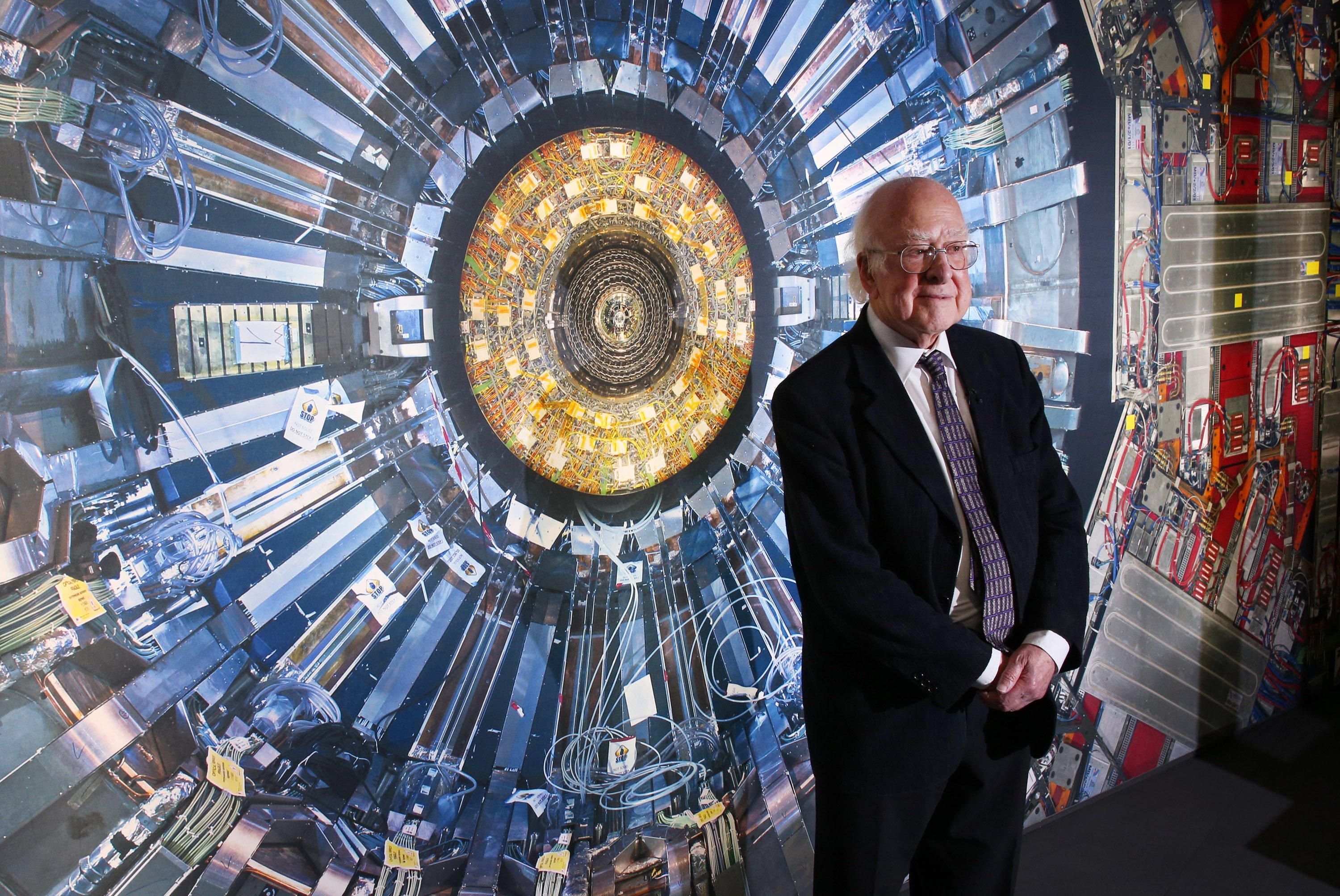Professor Peter Higgs in front of a photo of the Large Hadron Collider. File photo: TNS