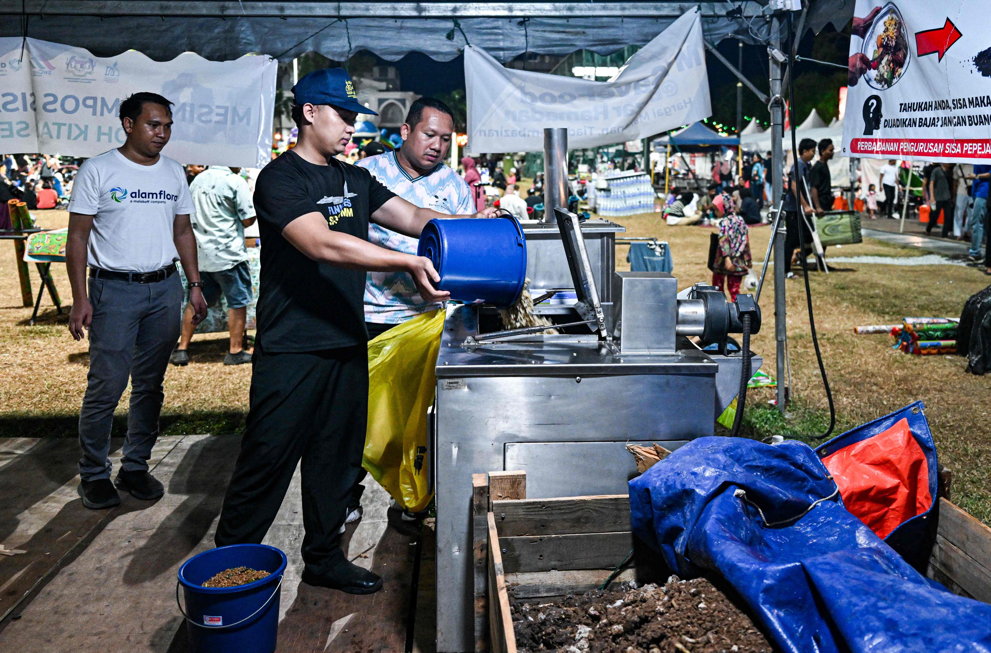 A Ramadan bazaar trader throws food waste into a composting machine in Kuantan, in Malaysia’s Pahang state, on April 3. After breaking their Ramadan fast, people throw their leftovers into a machine that converts the food scraps into organic fertiliser for crops as part of a Pahang government initiative to reduce food waste. Photo: AFP