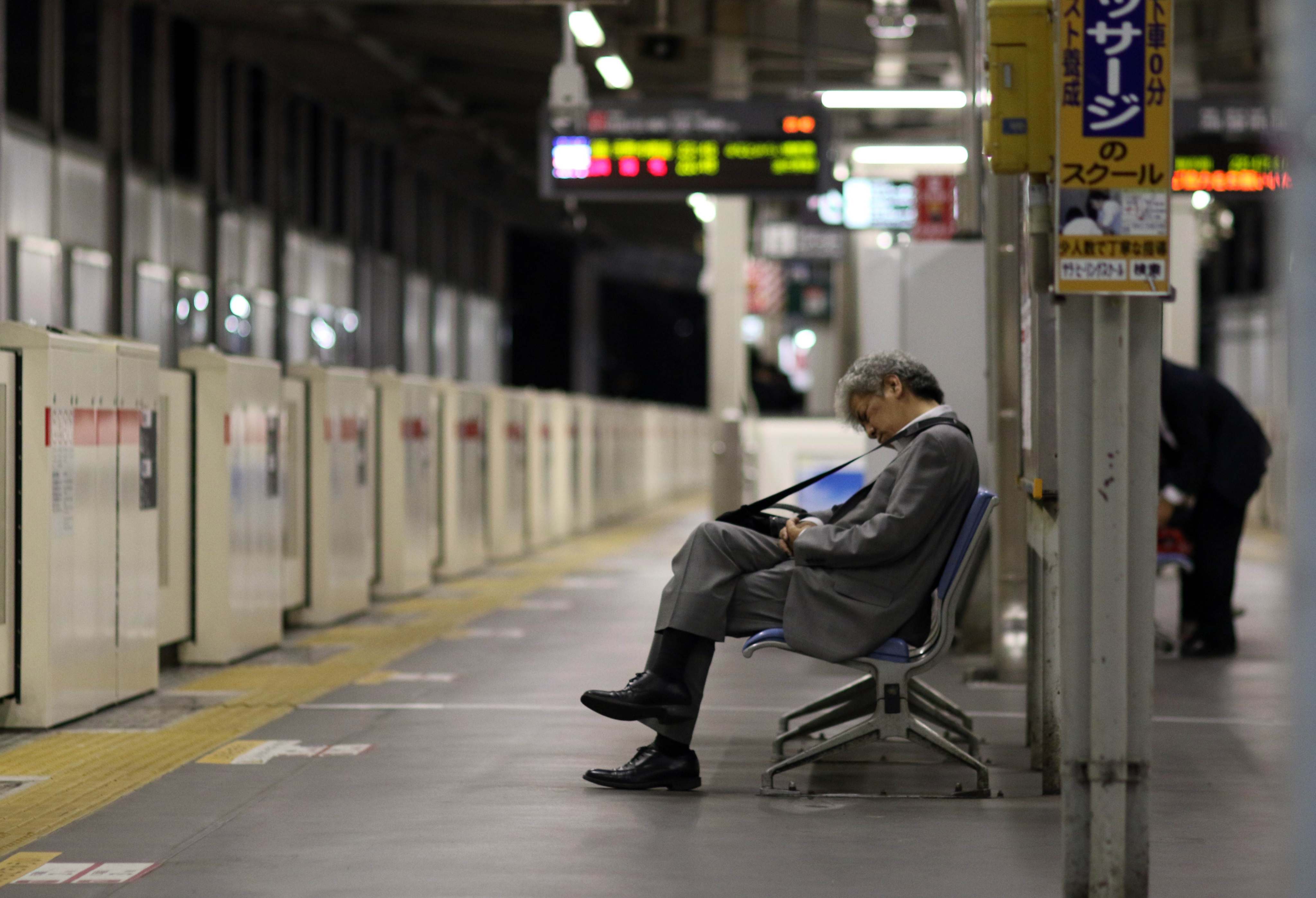 A businessman sleeping on a bench at a Tokyo train station. Photo: AFP 