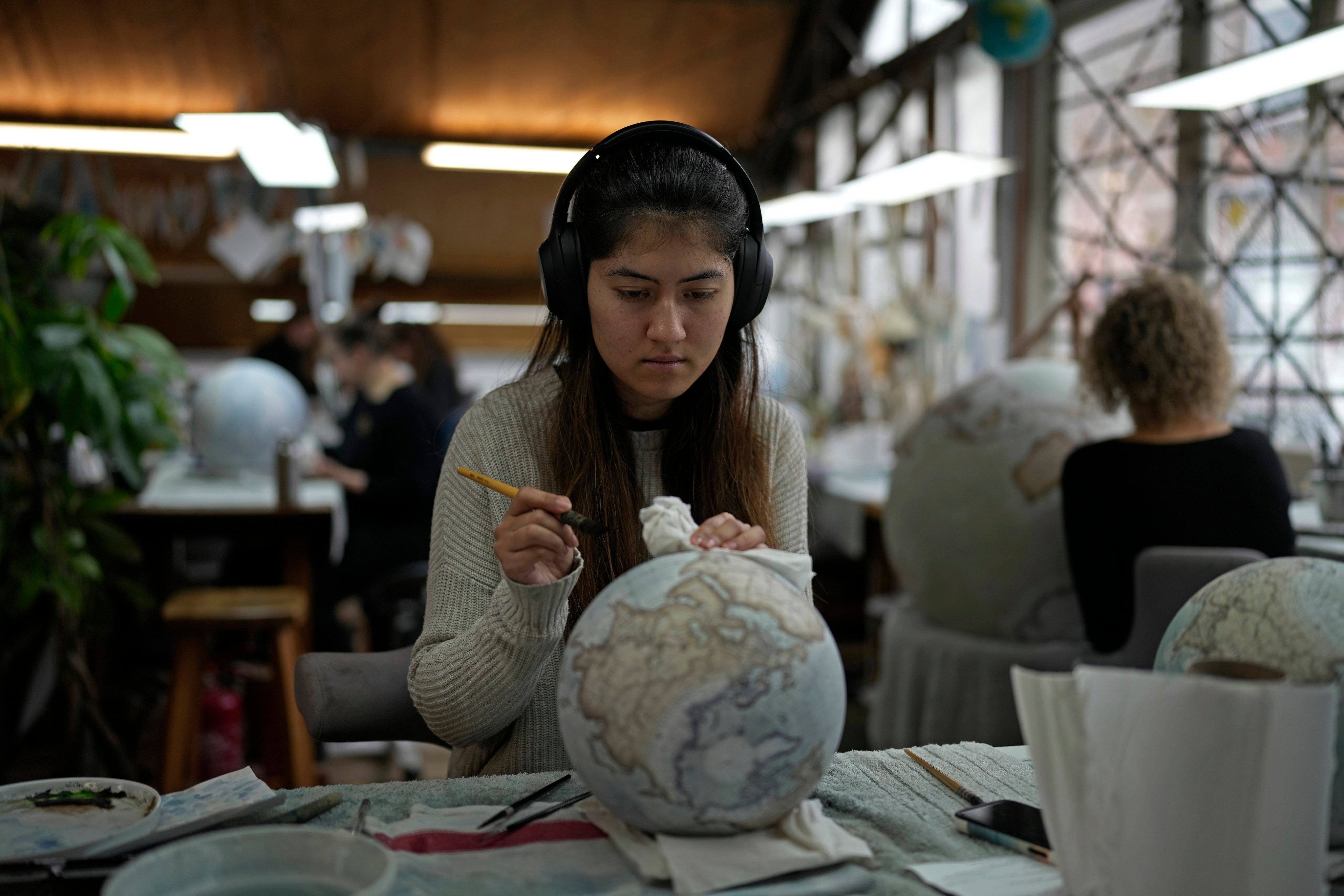 An artist paints a globe at the studio of Bellerby & Co Globemakers in London, England, on February 27, 2024. Many people still buy globes despite the invention of technologies like Google Earth and GPS. Photo: AP