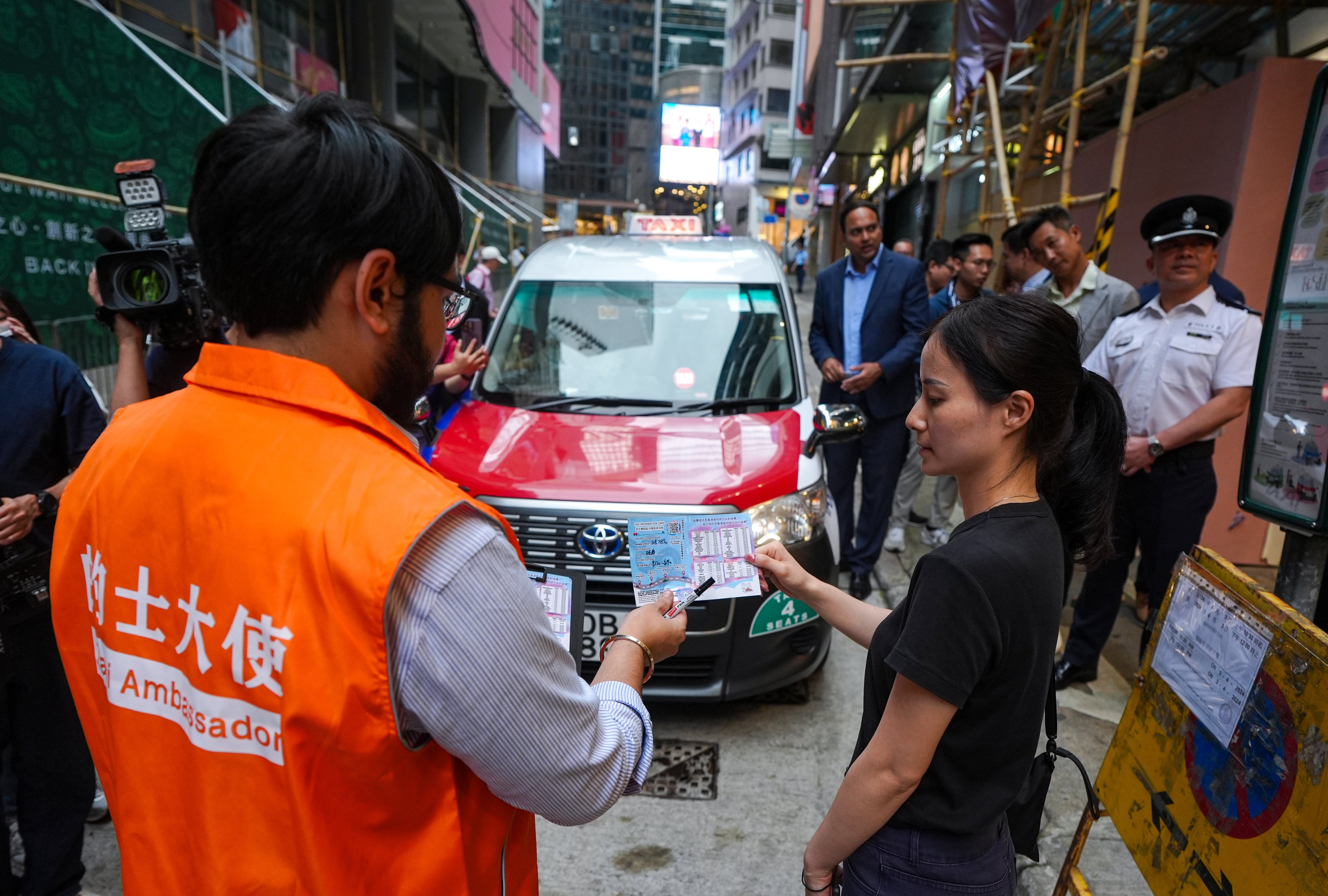 “Taxi ambassadors” will help passengers in Lan Kwai Fong fill out information about their rides. Photo: Eugene Lee
