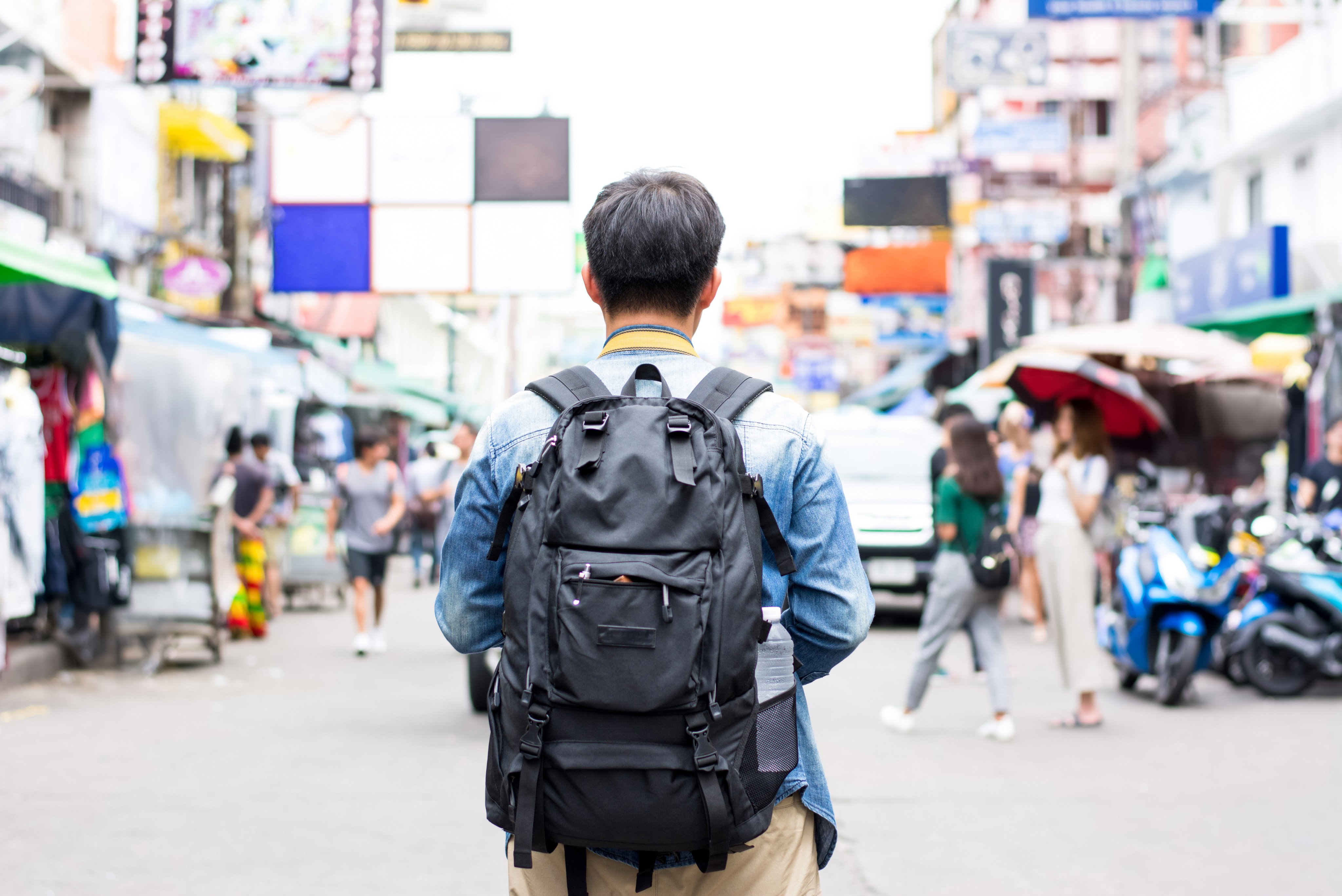 A backpacker walks through the Khao San Market in Bangkok, Thailand. Tile Pile passes on his beginner backpacking tips for Southeast Asia to his son as he starts his first solo trip. Photo: Shutterstock