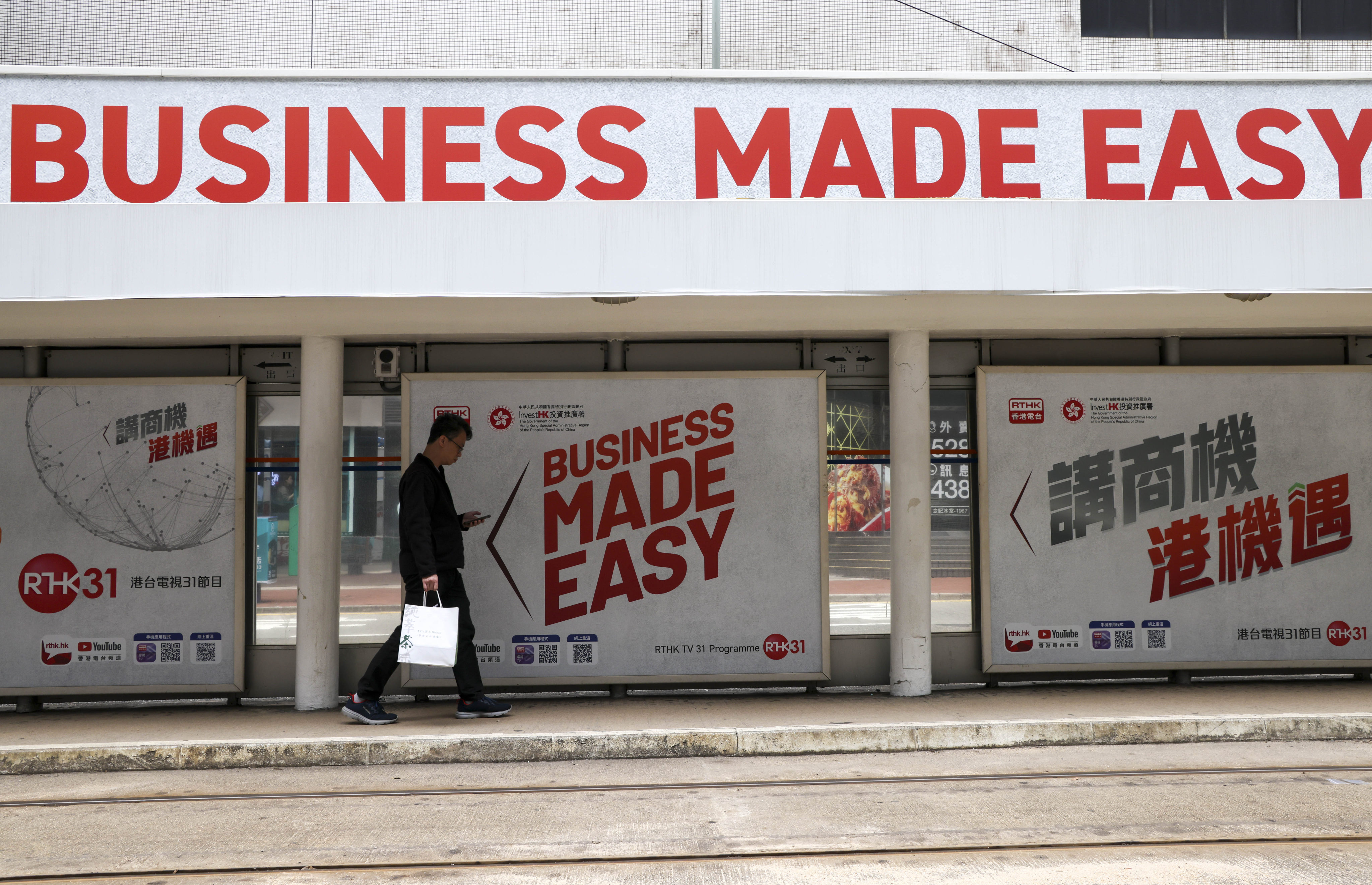 A man walks past an InvestHK advertisement at a tram stop in Taikoo on March 24. Photo: Jelly Tse