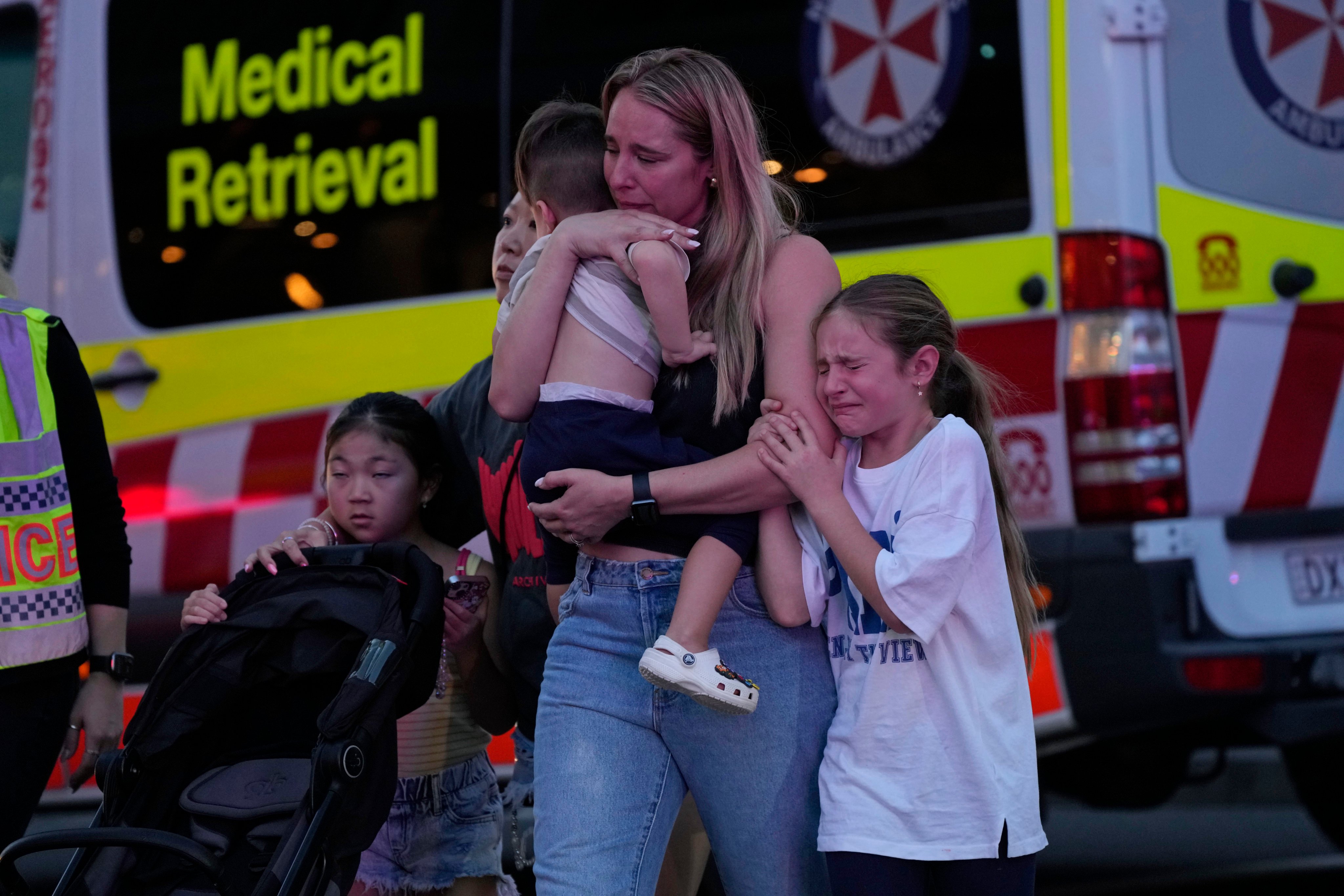 People are led out from a shopping centre in Sydney where multiple people were stabbed on Saturday.  Photo: AP