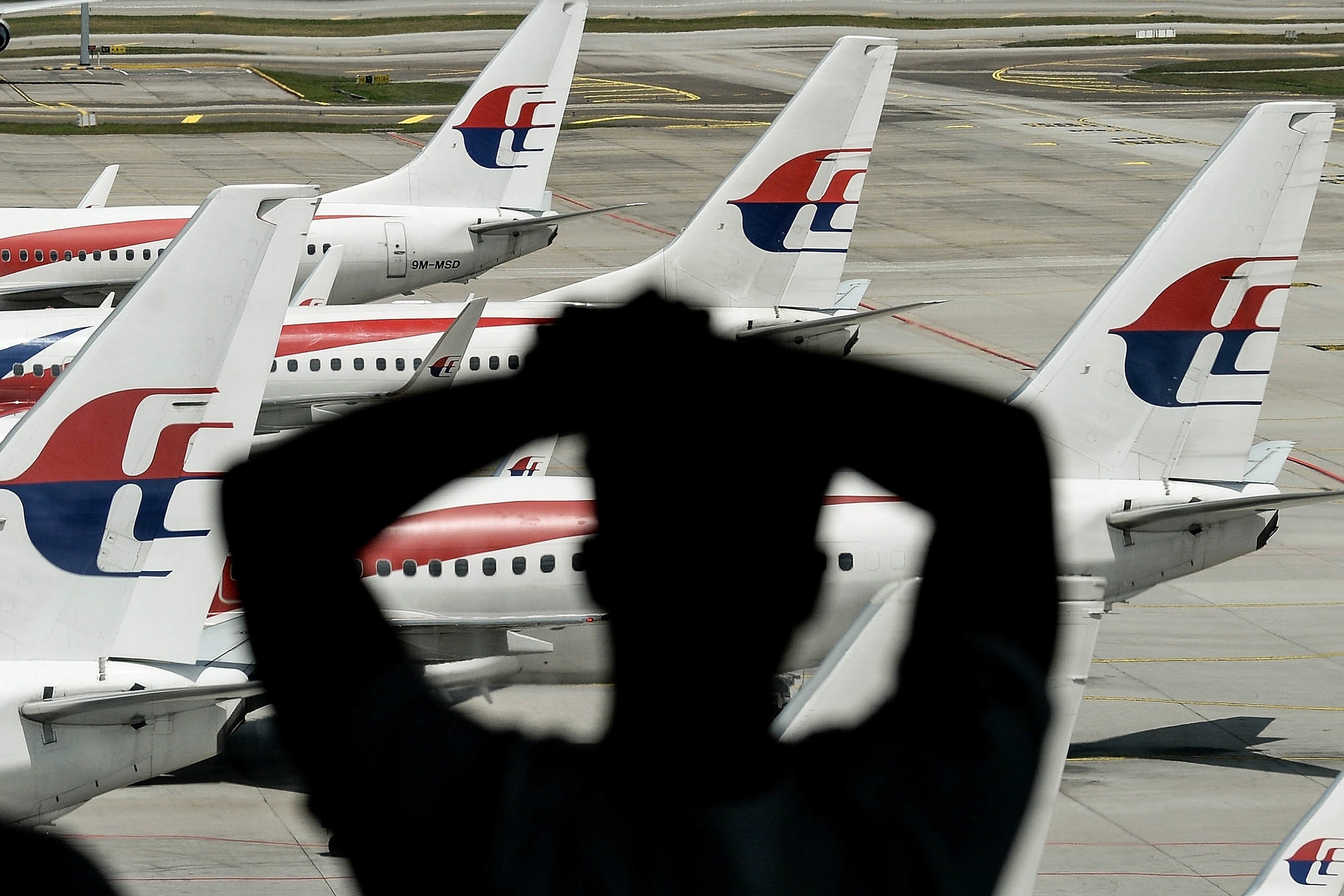 A man looks at aircraft on the tarmac at Kuala Lumpur International Airport. Police were investigating a rare shooting at the airport in connection to a domestic dispute. Photo: AFP