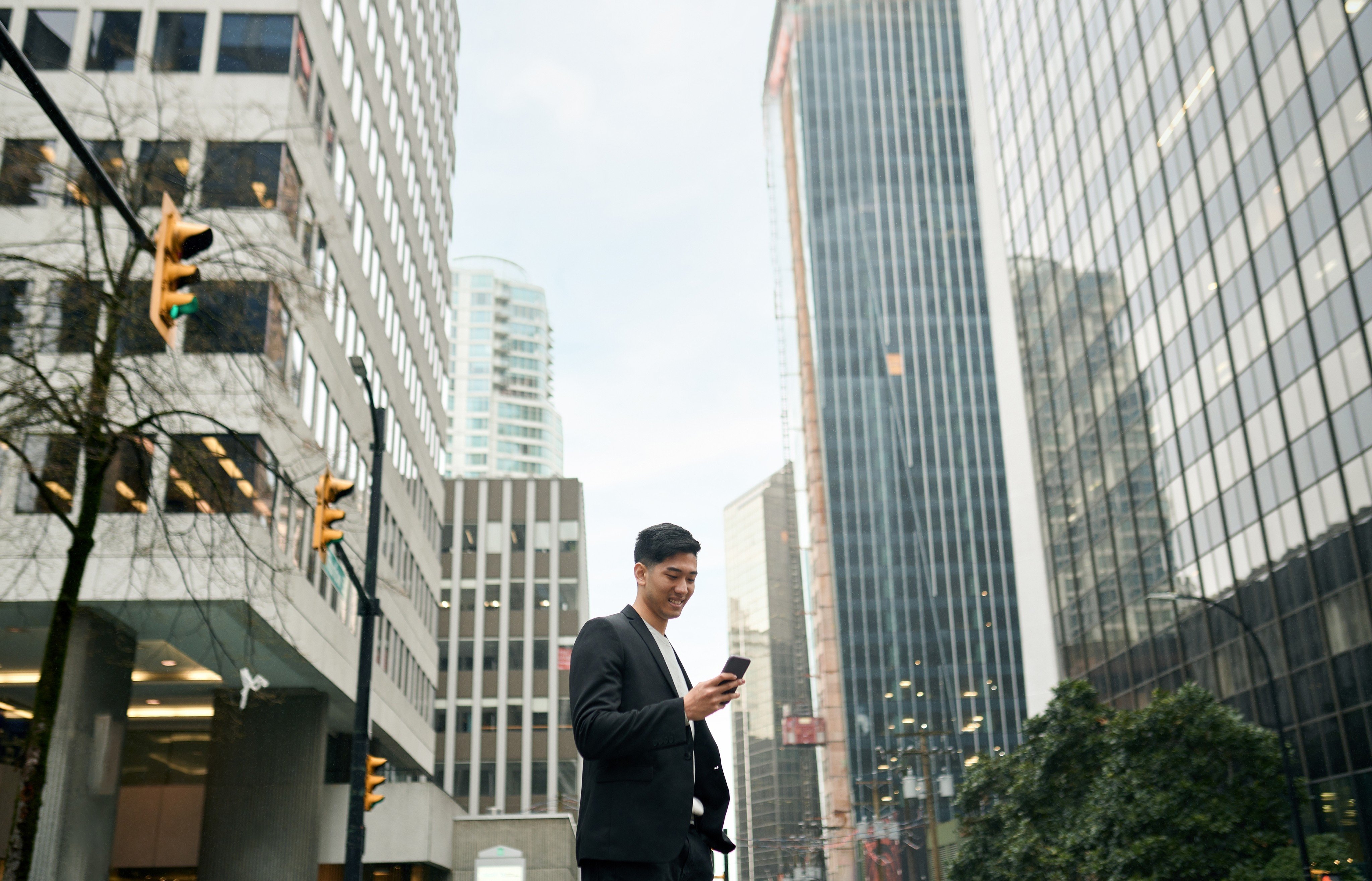 A Japanese business man investor stands amid downtown buildings. Numerous young Japanese workers are flocking to Australia in search of higher pay. Photo: Shutterstock