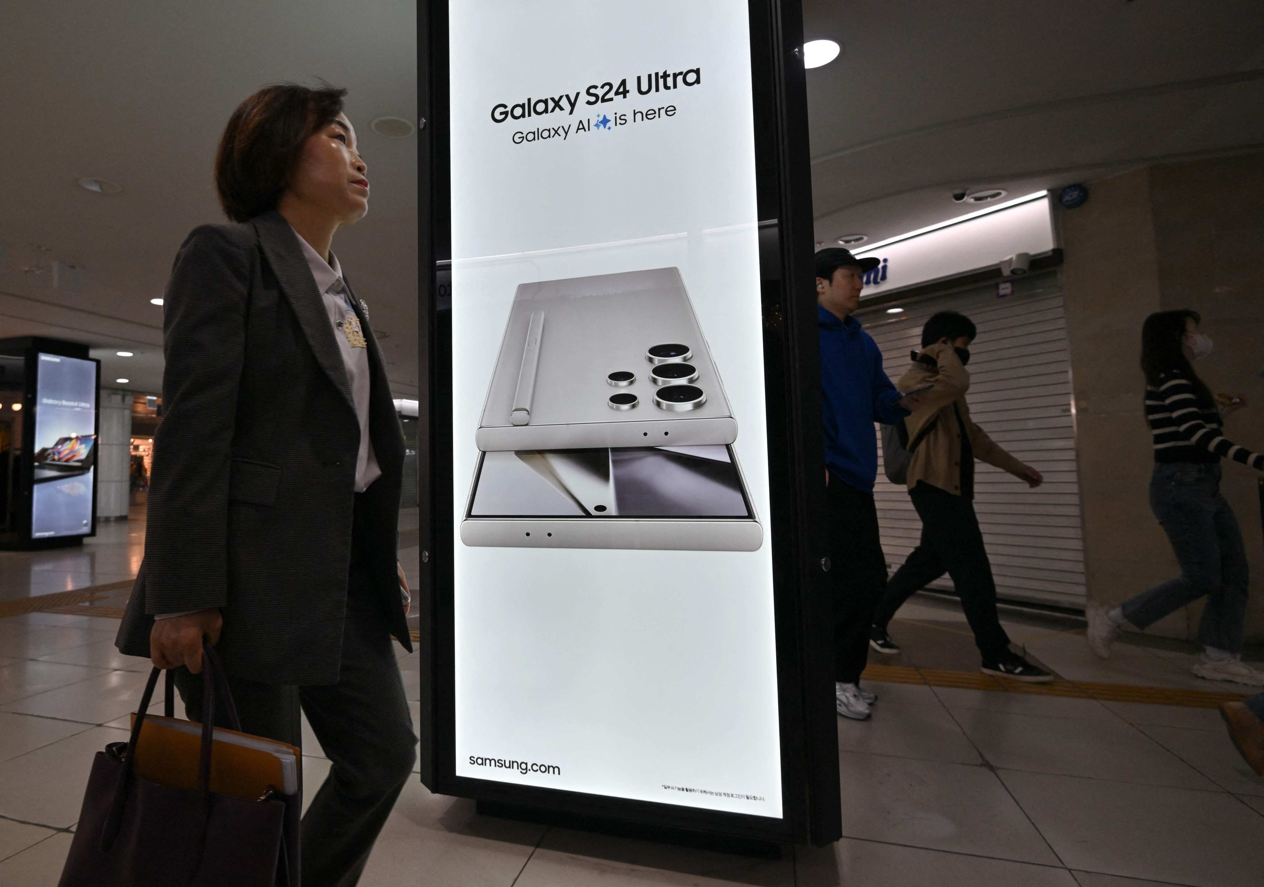 People walk past an advert display for Samsung Electronics' Galaxy S24 smartphone at a subway station in Seoul on April 5, 2024. Photo: AFP