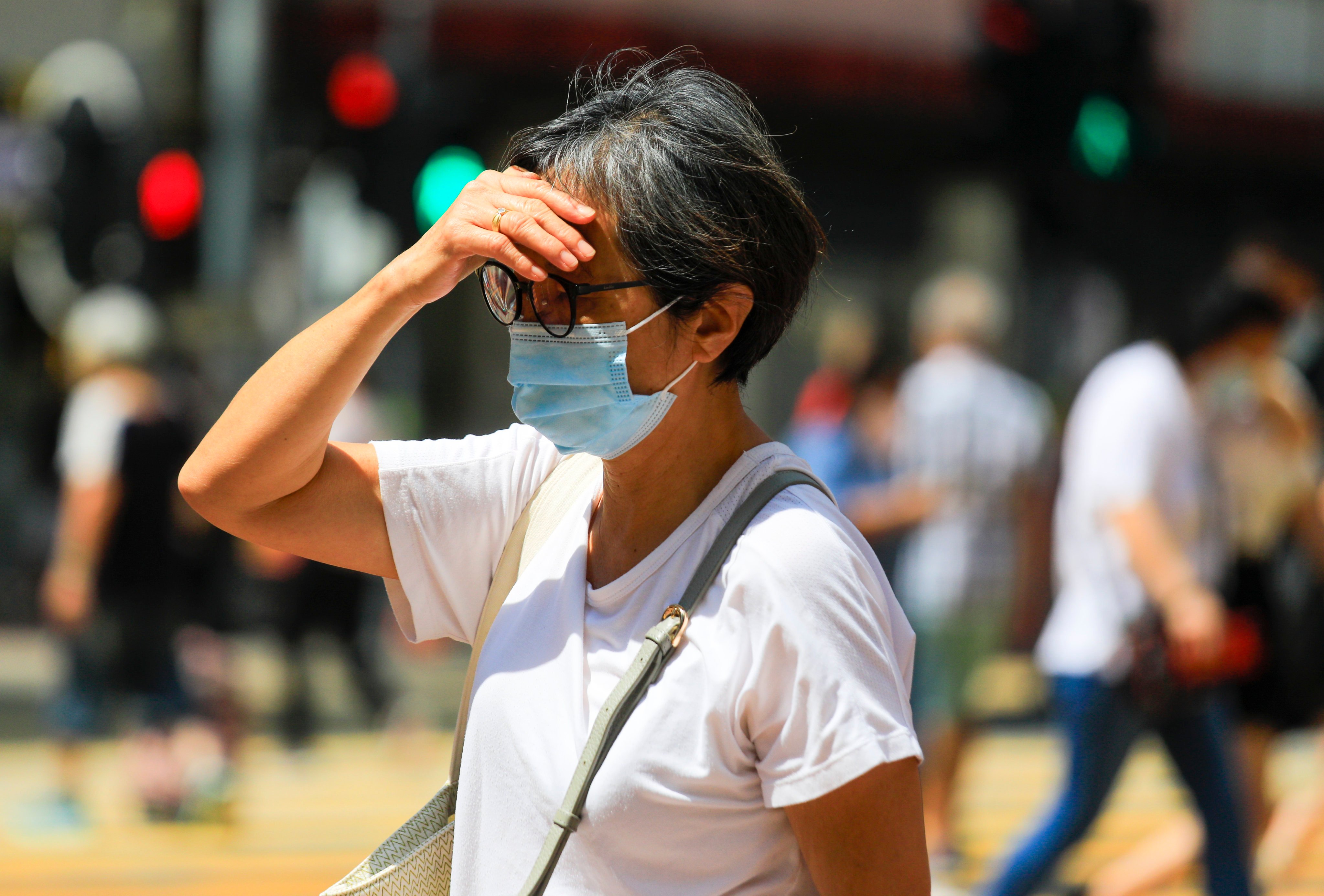 A woman shades her eyes in Causeway Bay, Hong Kong, on September 15, 2022. In Asia, the main problem is rising heat and more variable rainfall. Photo: Xiaomei Chen 