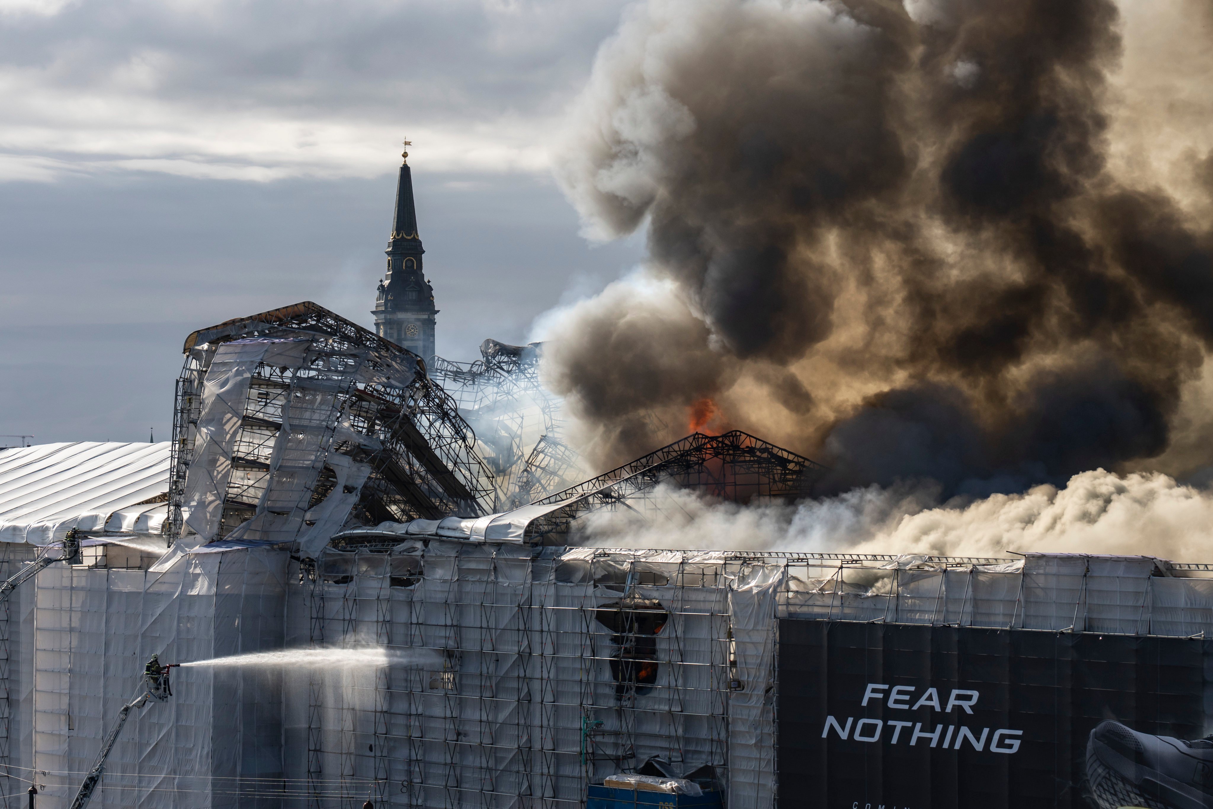 Firefighters work as smoke rises out of the Old Stock Exchange in Copenhagen, Denmark on Tuesday. Photo: AP