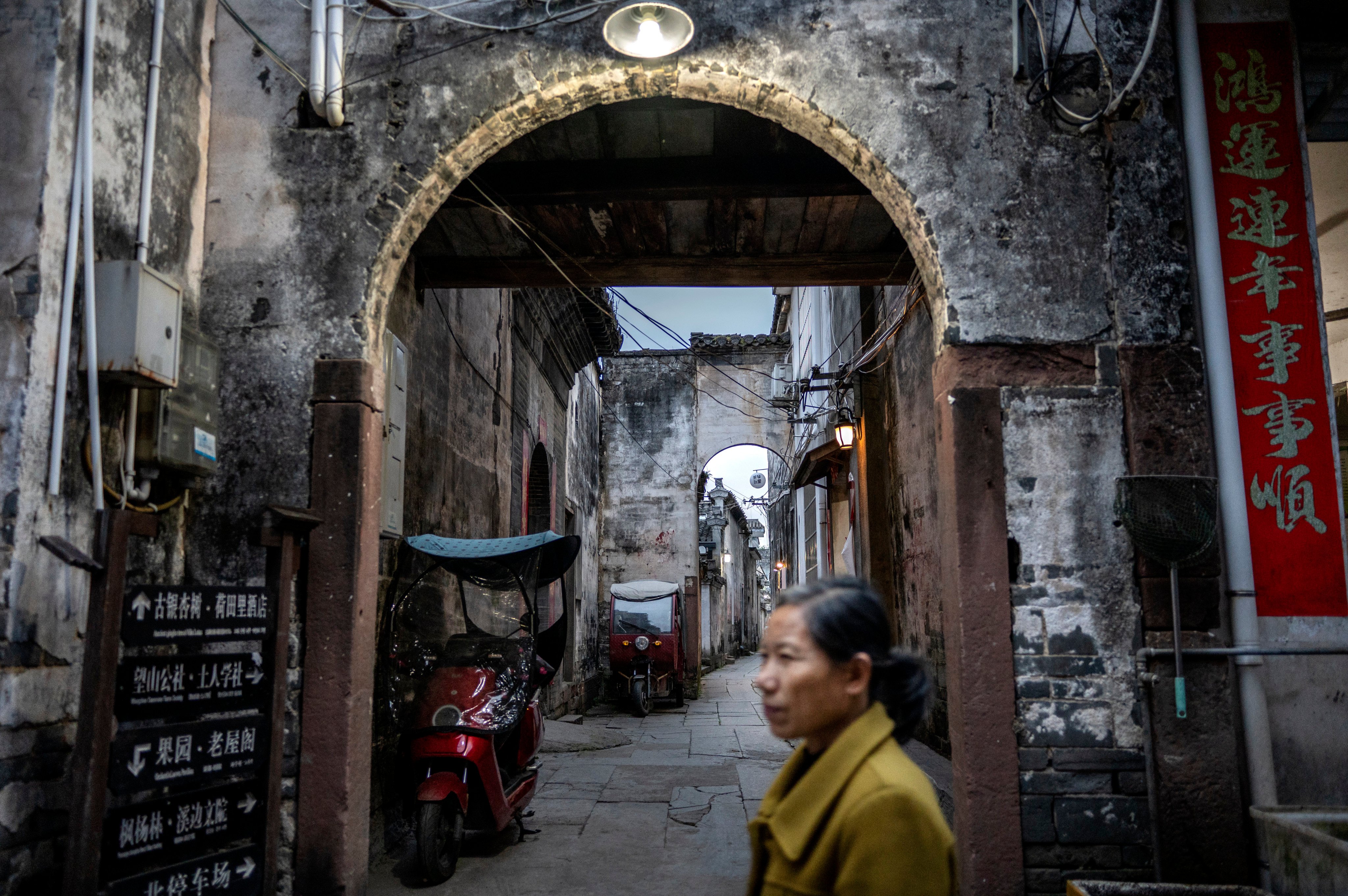 A woman walks by a an alleyway on May 10, 2023 in the traditional village of Xixinan, Anhui Province, southern China. Photo: Getty Images