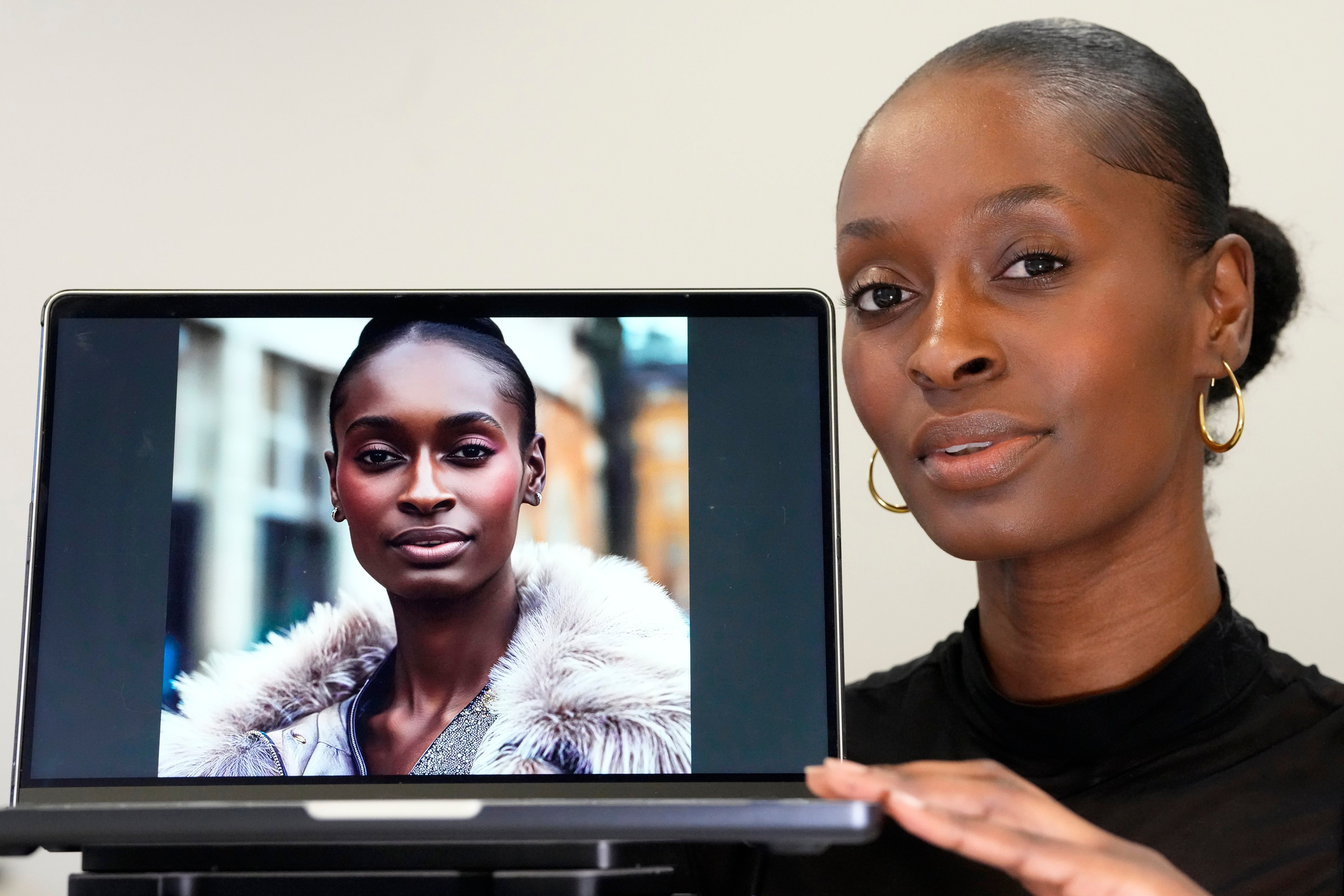 Fashion model Alexsandrah poses with a computer showing an AI generated image of her. Photo: AP