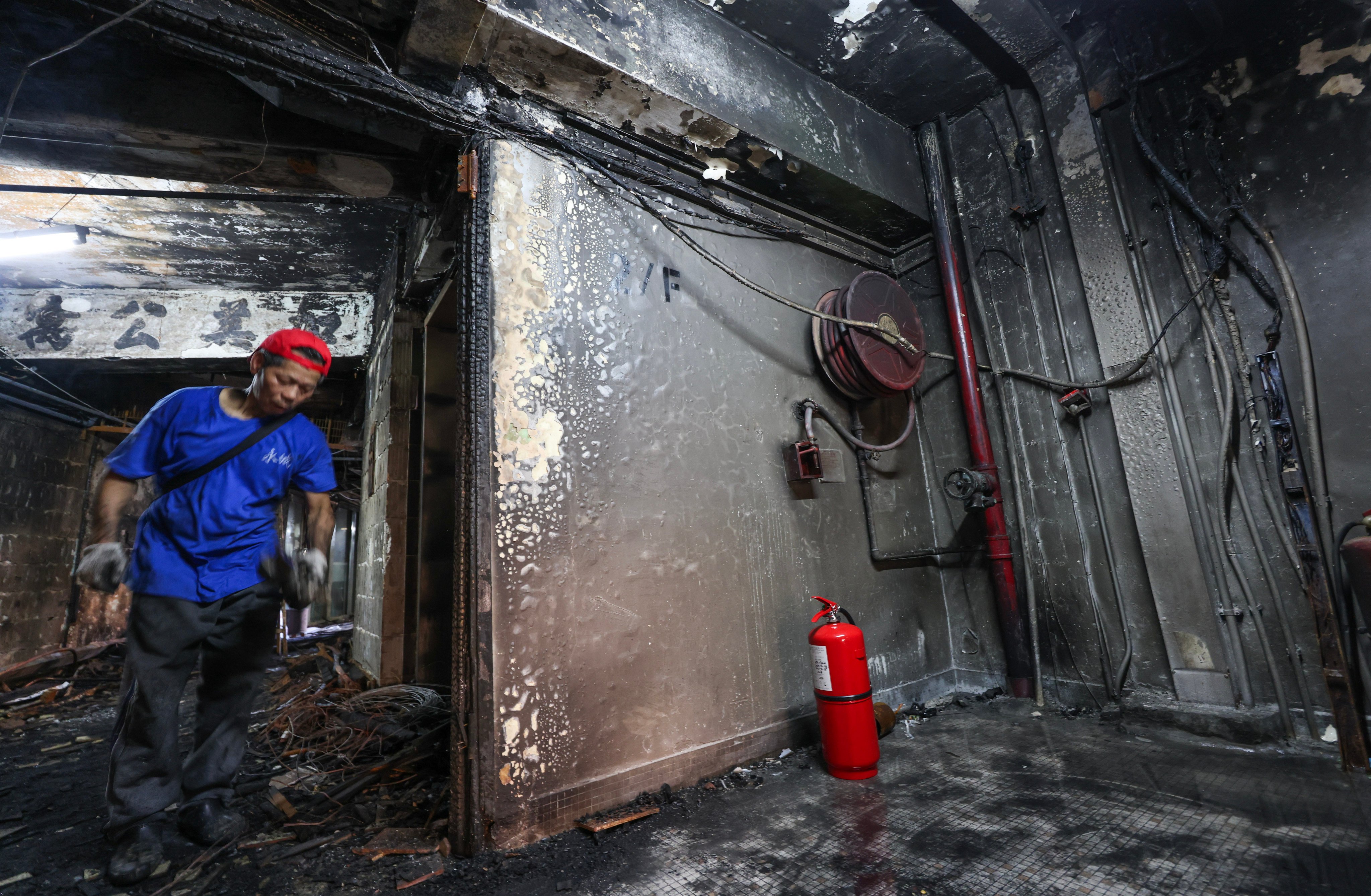 A worker carries out repairs at fire-damaged New Lucky House. Photo: Jelly Tse