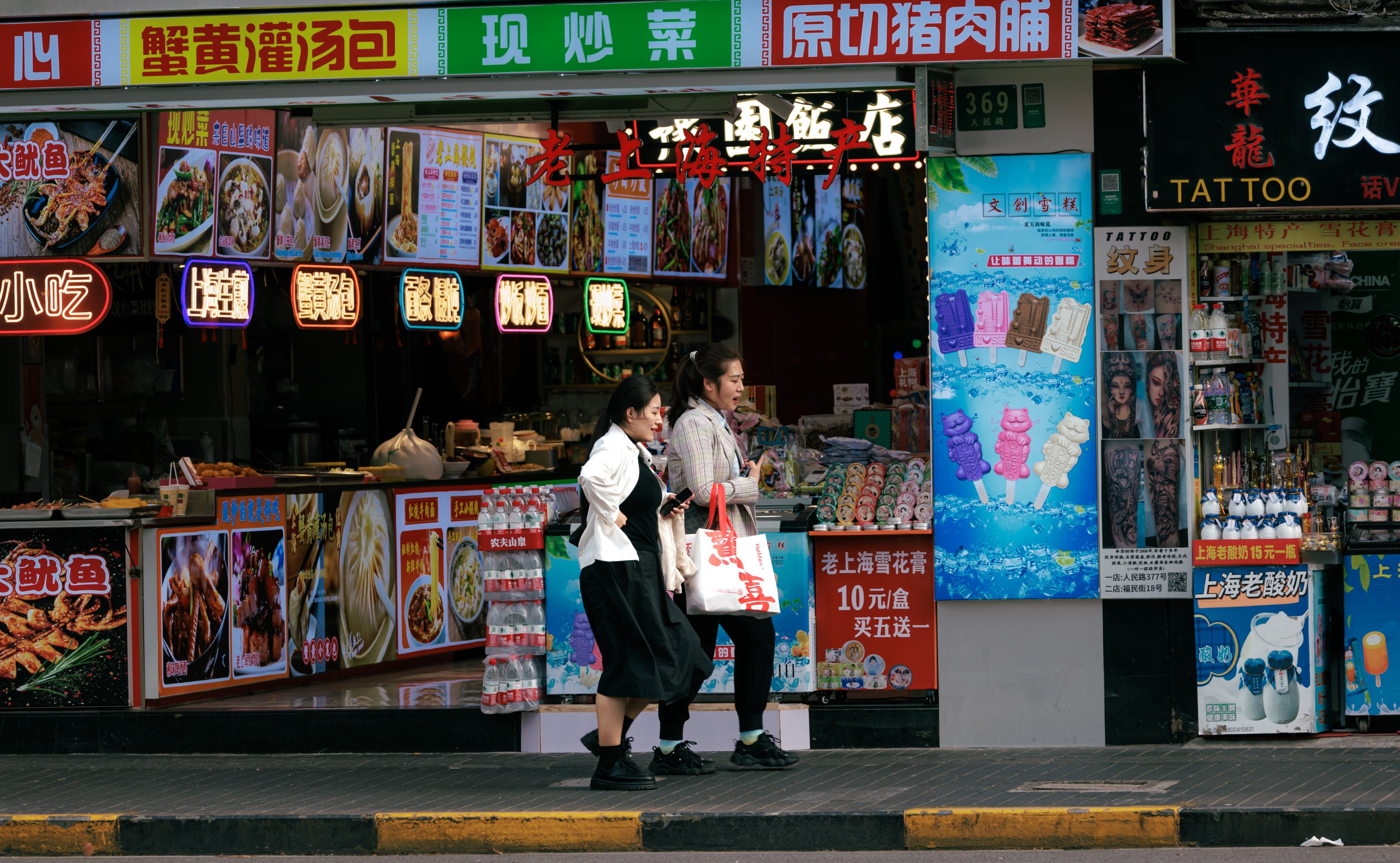 People walk past restaurants on a street in Shanghai on April 15, 2024.Photo: EPA-EFE