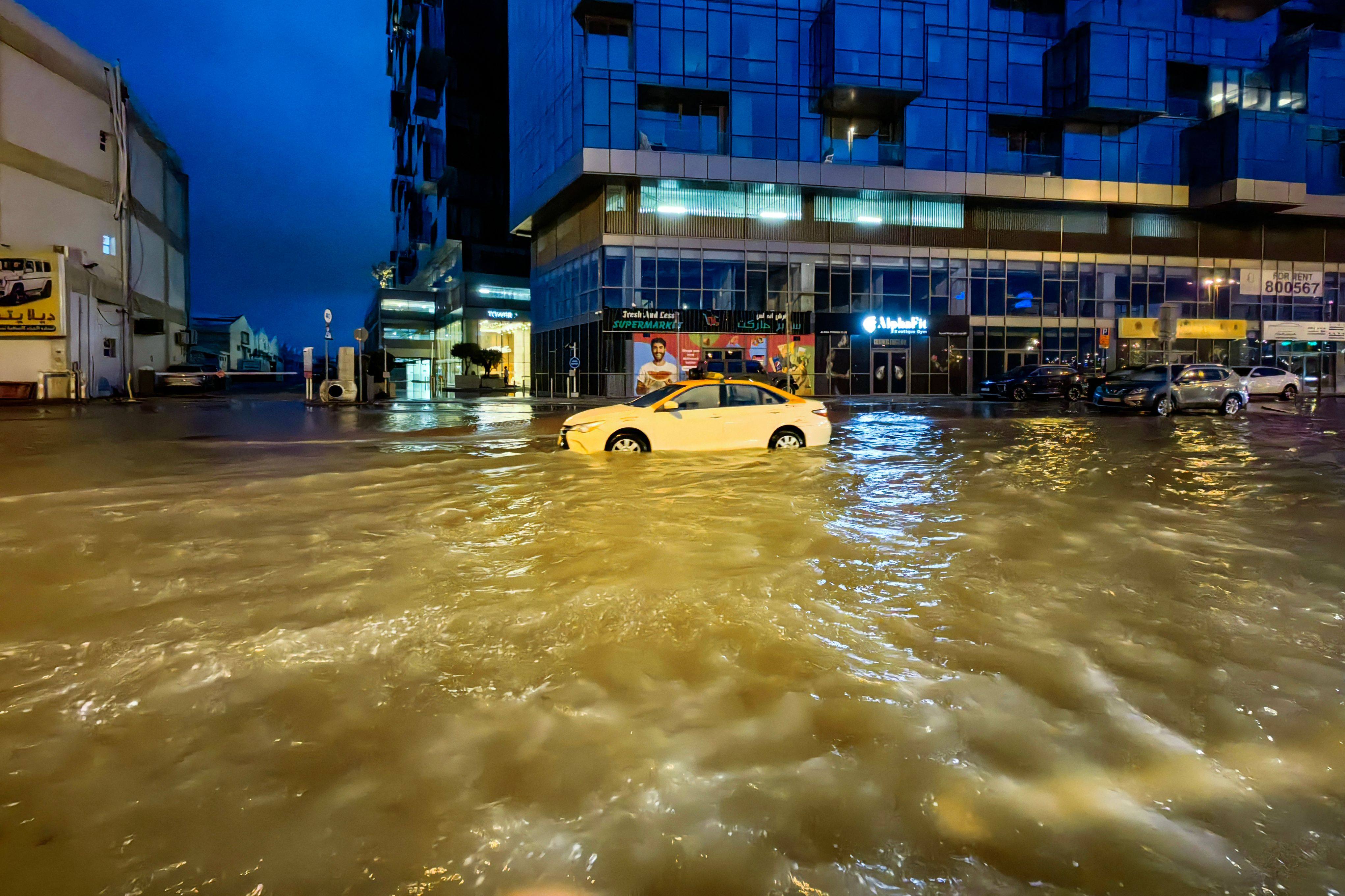 A taxi drives through a flooded street following heavy rains in Dubai. Photo: AFP