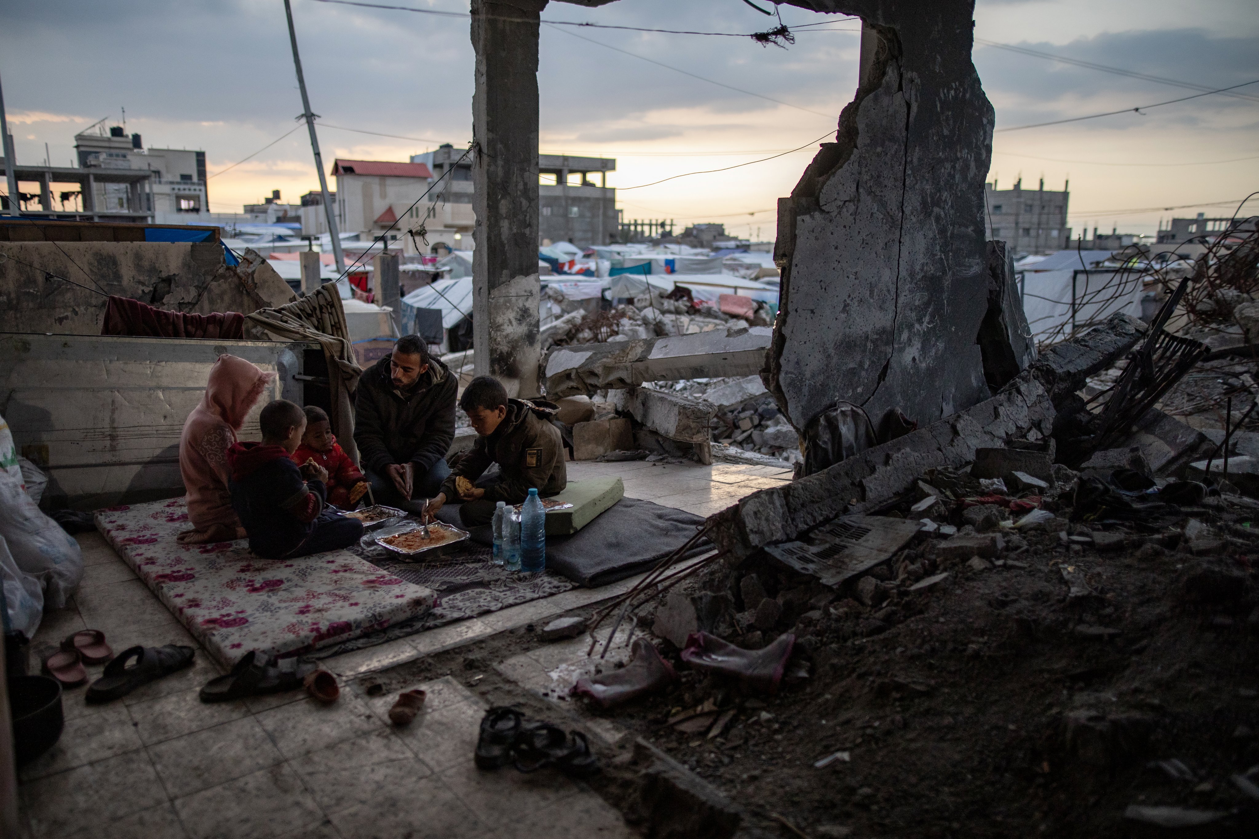 An internally displaced Palestinian family prepares for iftar, the fast-breaking evening meal during the Muslim holy month of Ramadan, in a destroyed house, in Rafah, in the southern Gaza Strip on March 19. Photo: EPA-EFE
