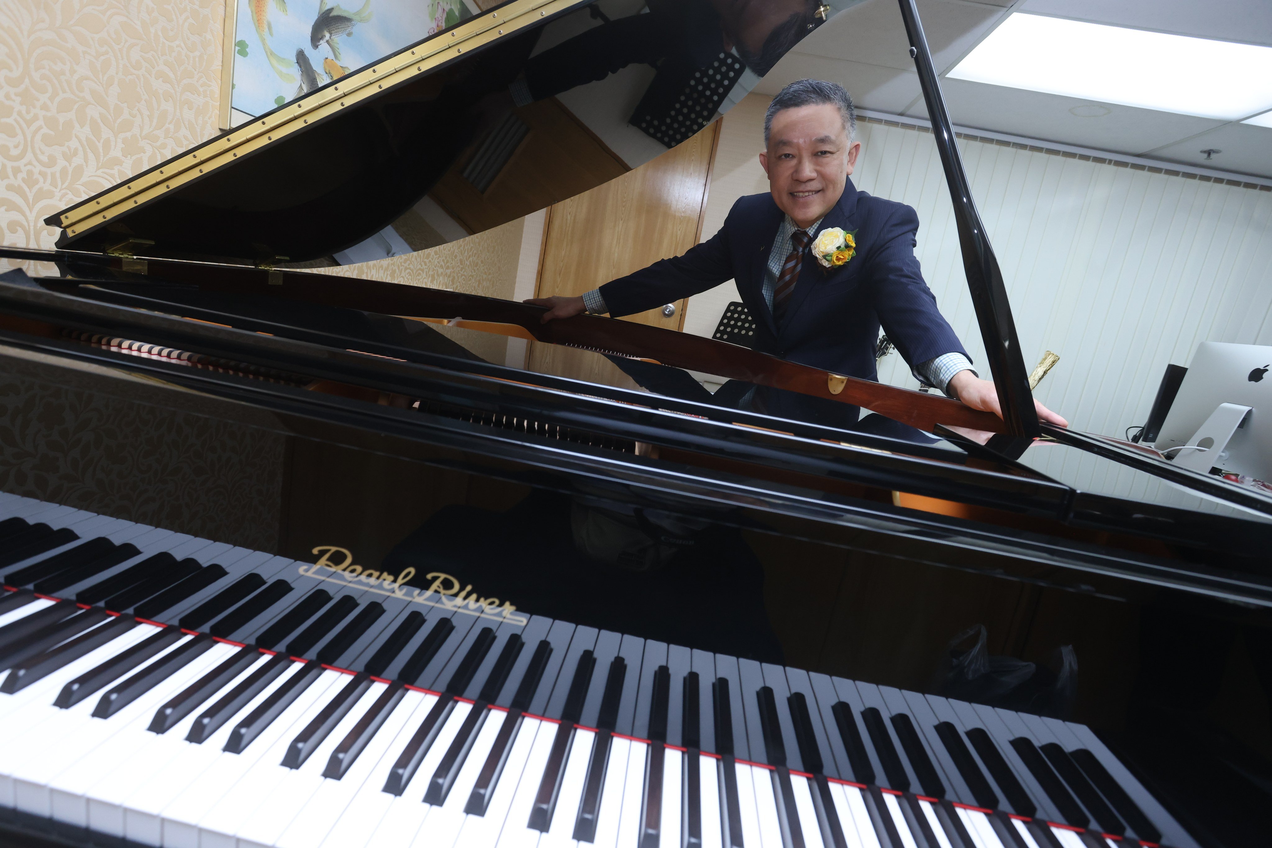 Pearl River Piano Global Head of Marketing Leng Tshua, with a Pearl River grand piano, at his offices in Kwai Chung. 21DEC23 SCMP / Jonathan Wong