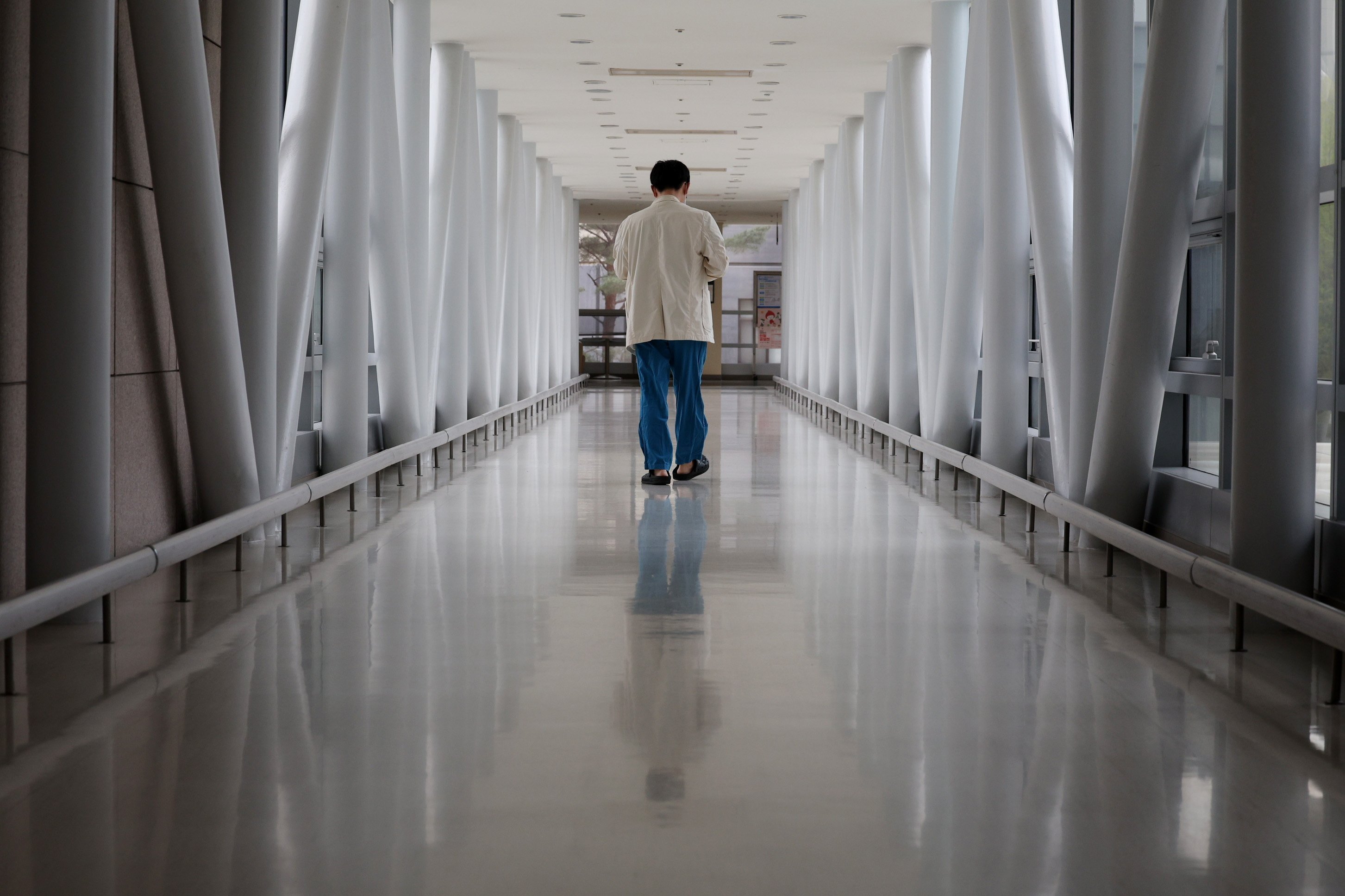 A medical worker walks down a hallway in a hospital in Seoul, South Korea, on April 10 amid an ongoing stand-off between the government and doctors over a plan to boost the medical school admission quota. Photo; EPA-EFE/Yonhap