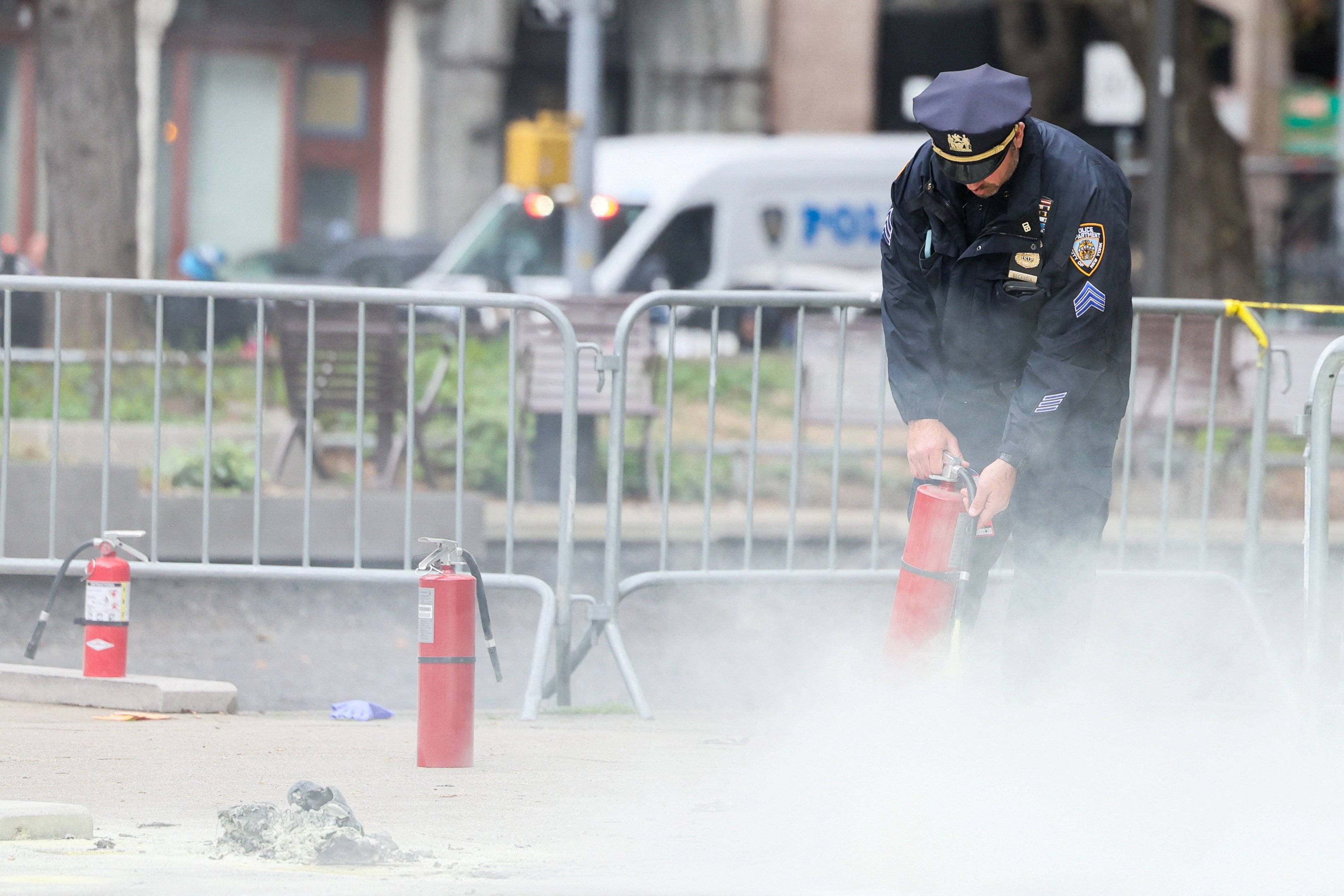 A police officer uses a fire extinguisher as emergency personnel respond to the scene where a person was covered in flames outside the New York courthouse where former US President Donald Trump’s criminal hush money trial is under way on Friday. Photo: Reuters