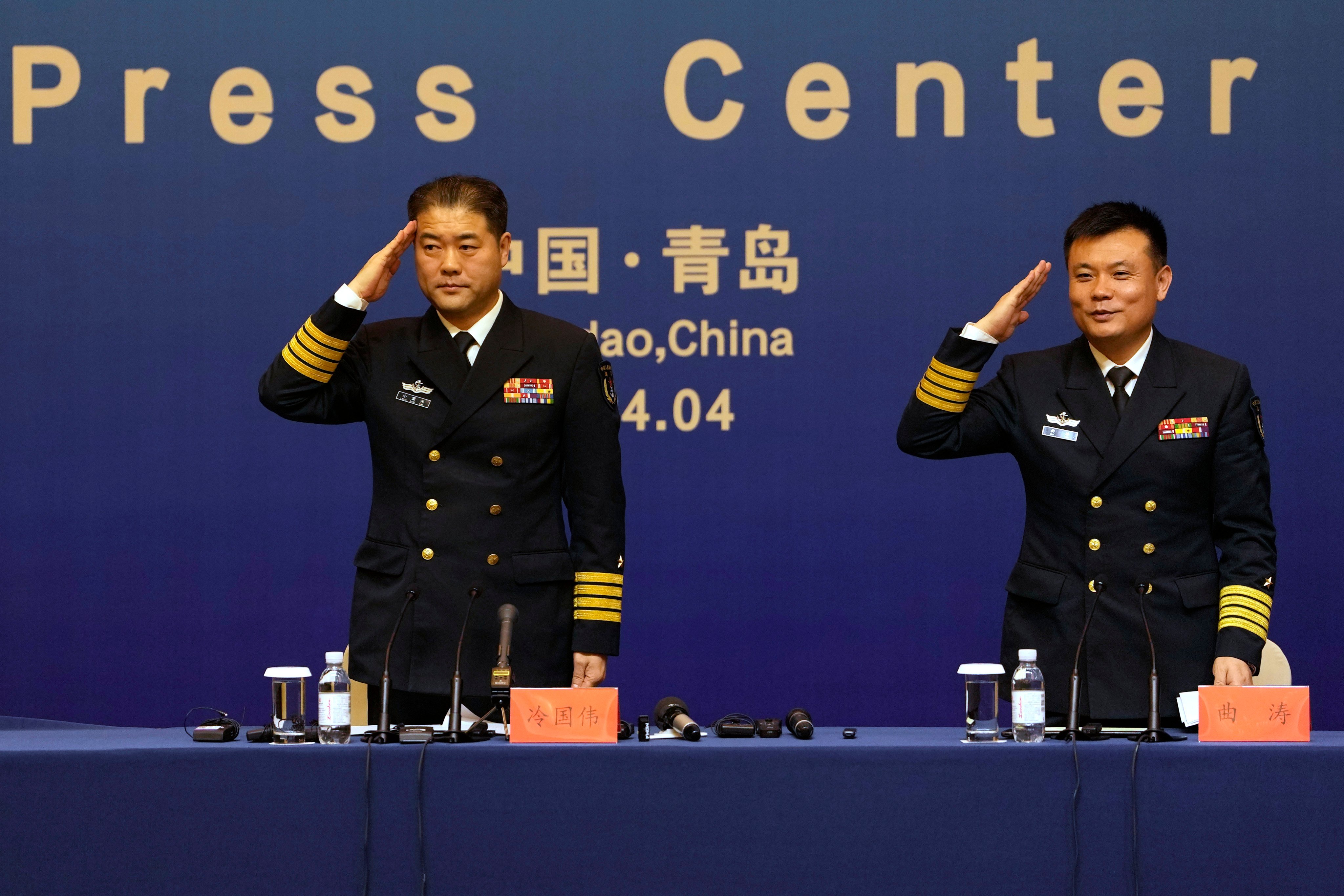 Senior Colonel Qu Tao (right) and a PLA Navy spokesman salute at the end of a press conference on Saturday in Qingdao, in eastern China’s Shandong province. Photo: AP 
