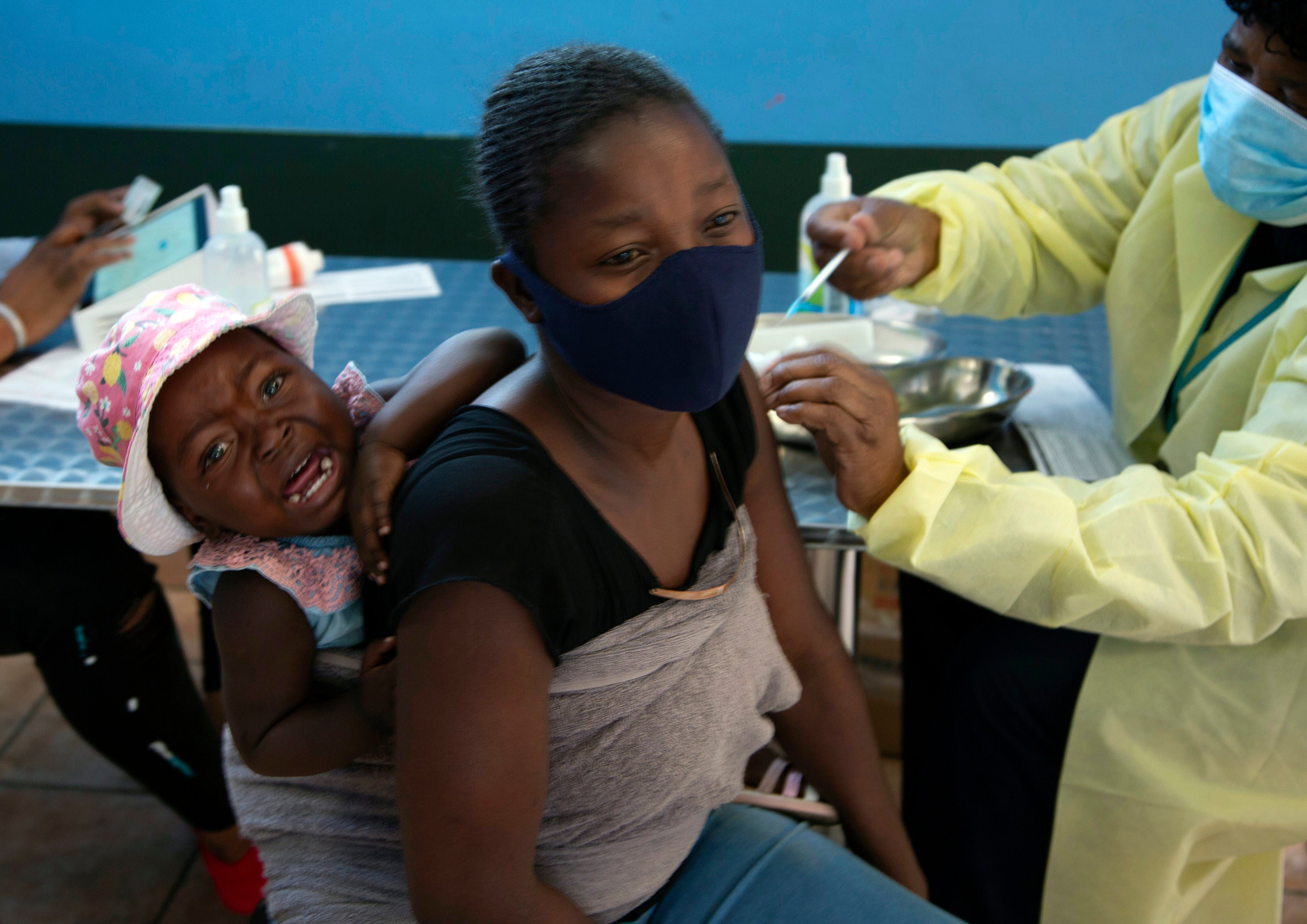 A baby cries as her mother receives a Covid-19 vaccine in a township near Johannesburg, South Africa, on October 21, 2021. Photo: AP