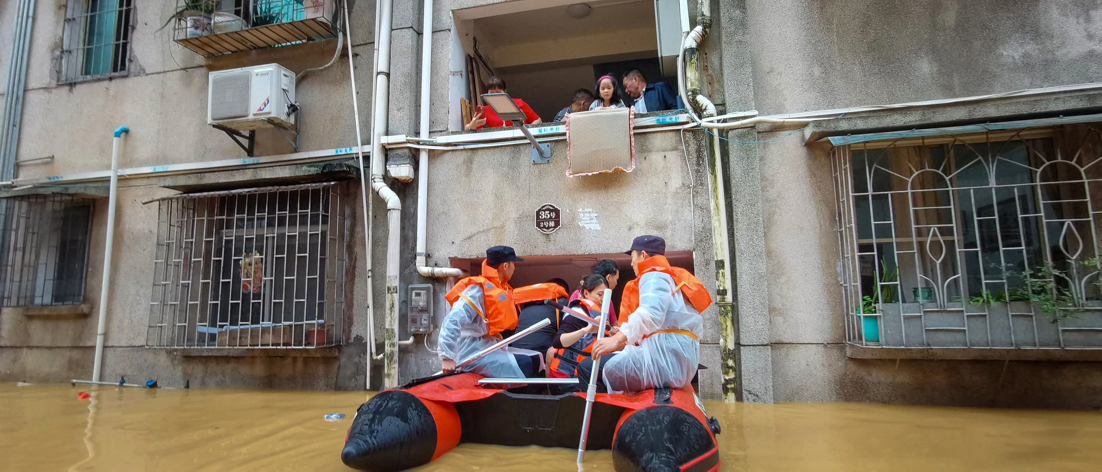 Shaoguan emergency workers help stranded residents evacuate their home on Saturday. Photo: Xinhua