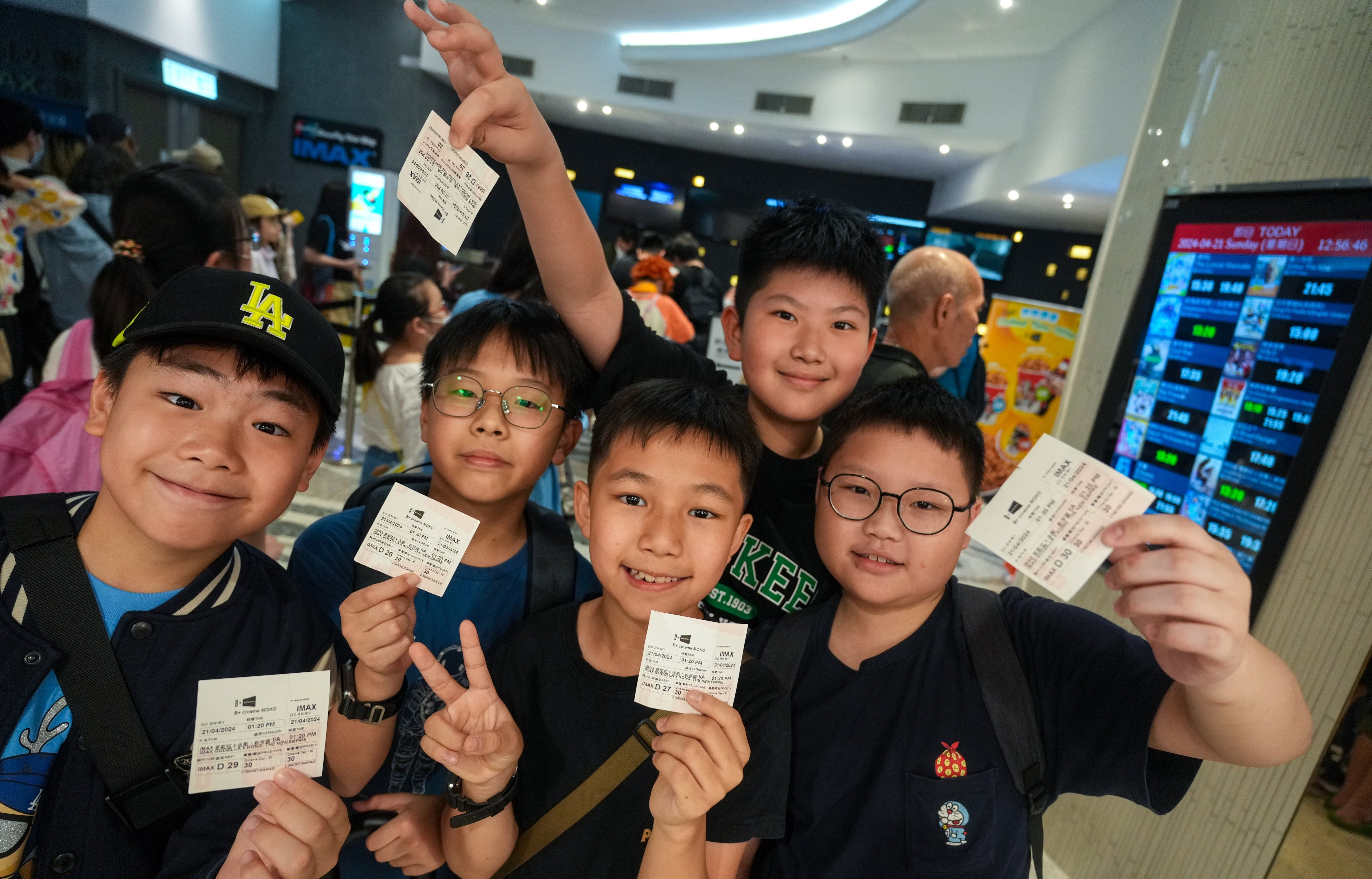 Happy young film fans show off their cut-price cinema tickets on Cinema Day. Photo: Sam Tsang