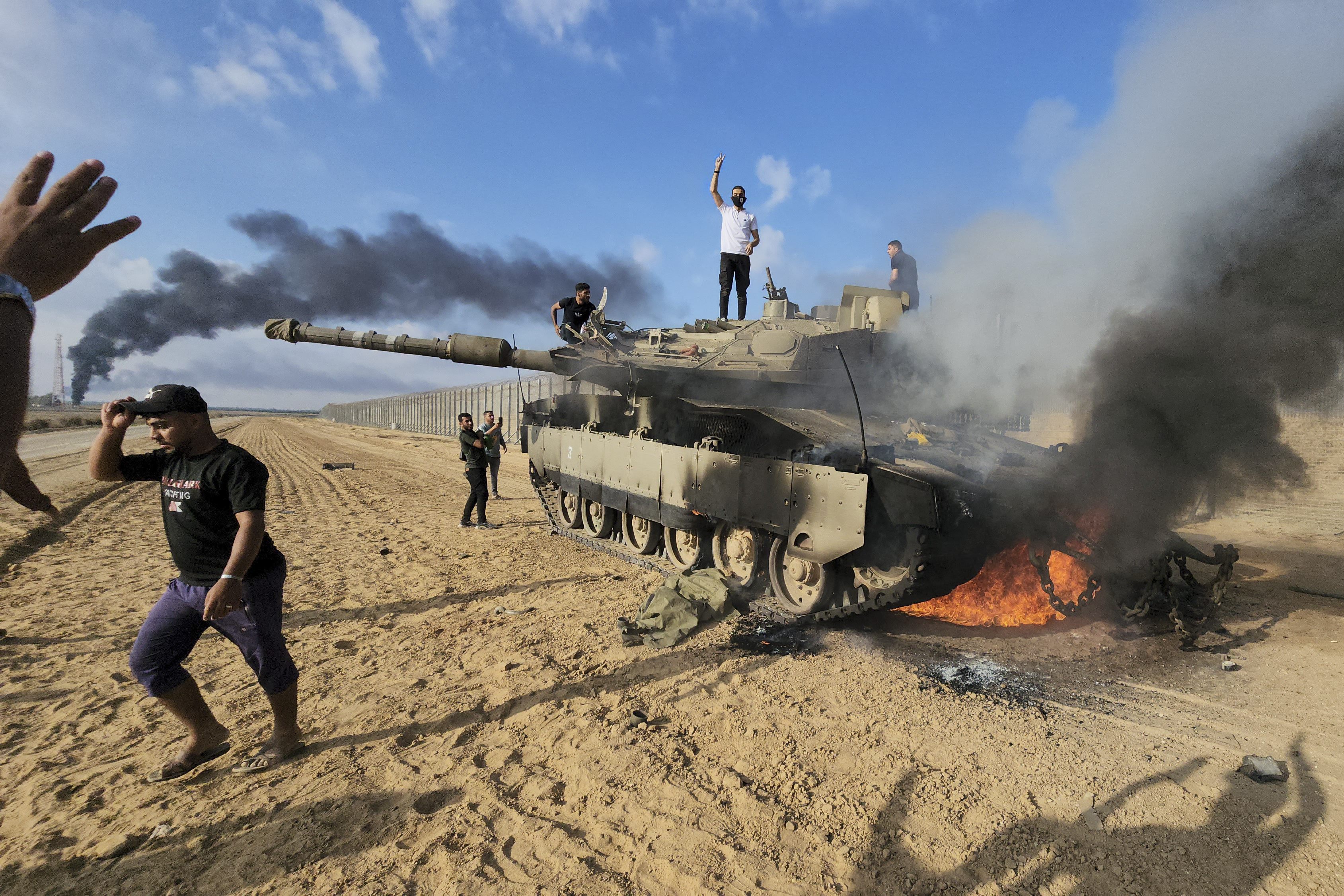 Palestinians celebrate by a destroyed Israeli tank on October 7, 2023. File photo: AP