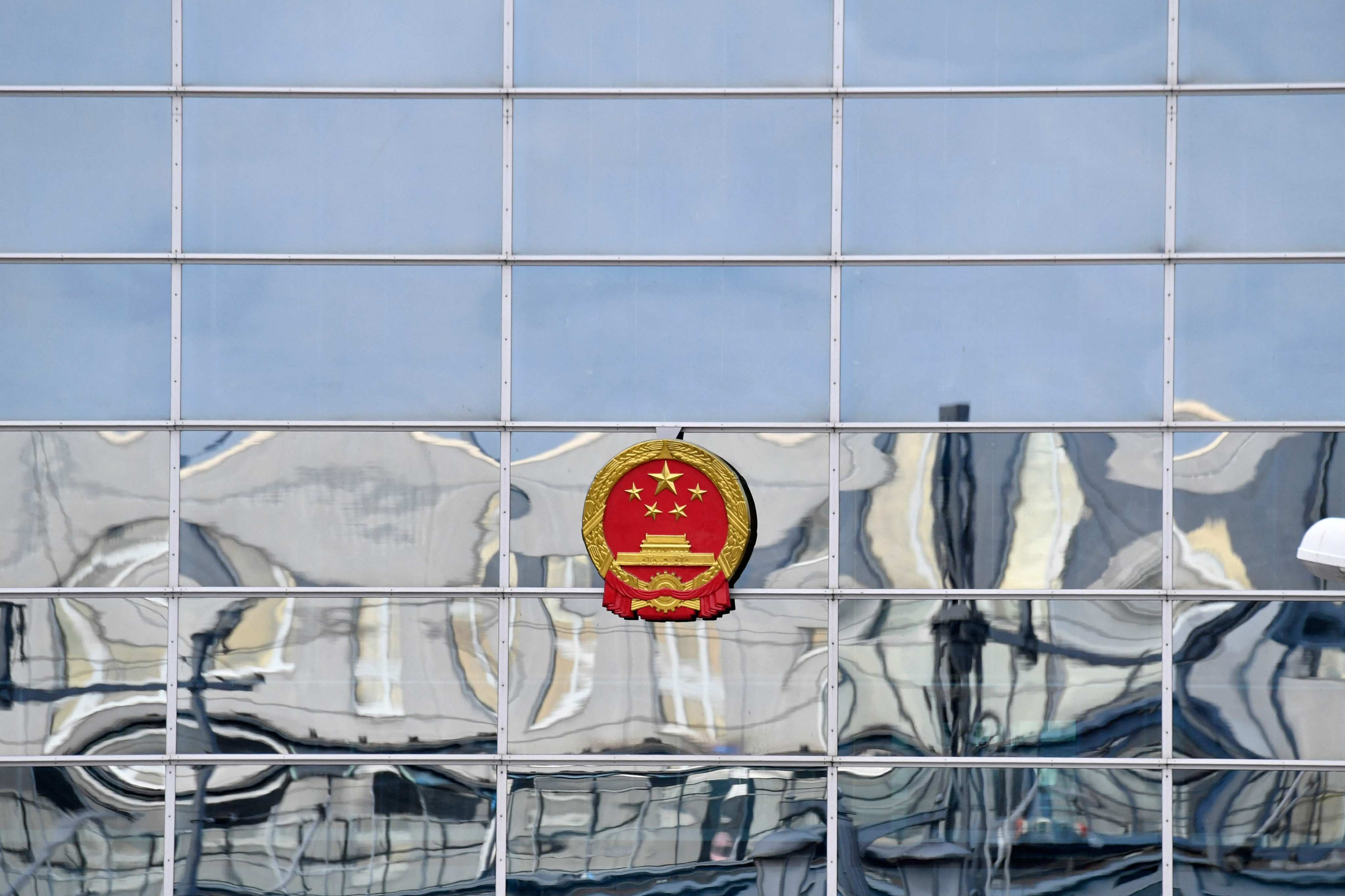 A building is reflected in the facade of the Chinese embassy in Berlin. Investigators on Monday arrested three German nationals in western Germany on suspicion of spying for China, prosecutors say, accusing them of gathering information on technology that could be used for military purposes. Photo: AFP