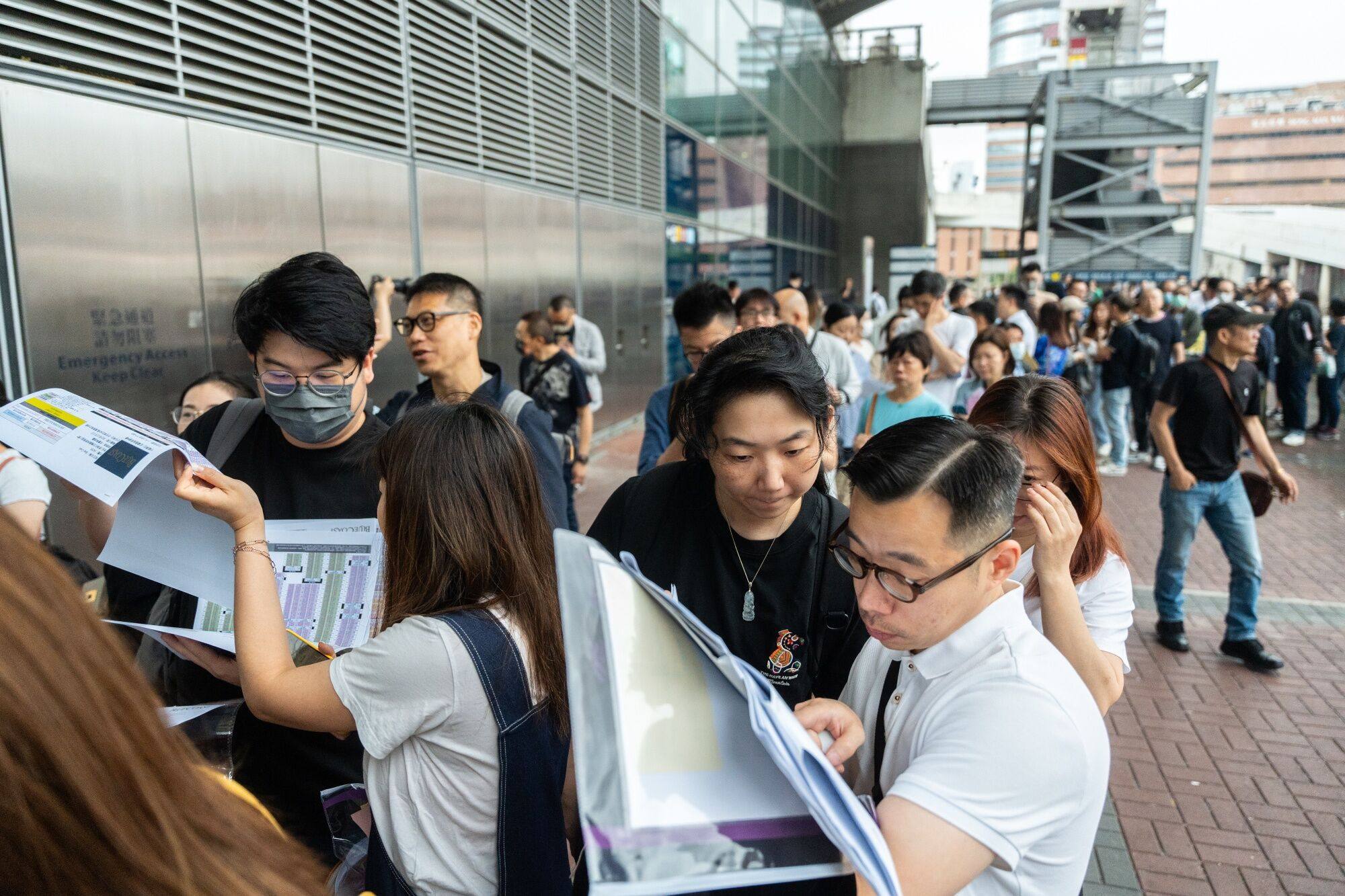 Prospective buyers stand in line outside the sales office of a housing project in Hong Kong on April 6. The prospect of interest rates staying higher for longer will induce developers to keep pricing their units at a discount, helping underpin the revival in demand. Photo: Bloomberg