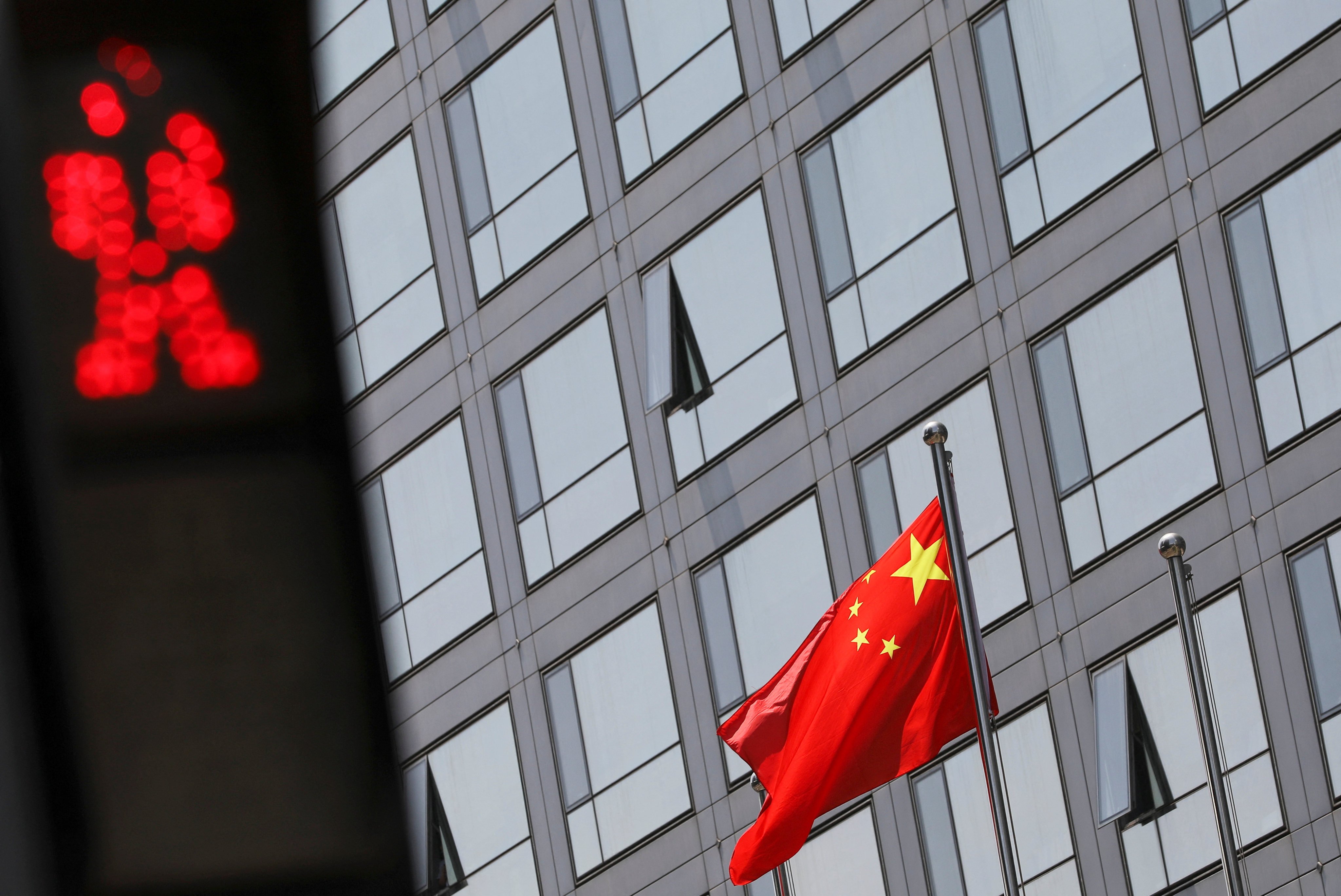 A Chinese national flag flutters outside the China Securities Regulatory Commission building on Financial Street in Beijing, on July 9, 2021. Photo: Reuters