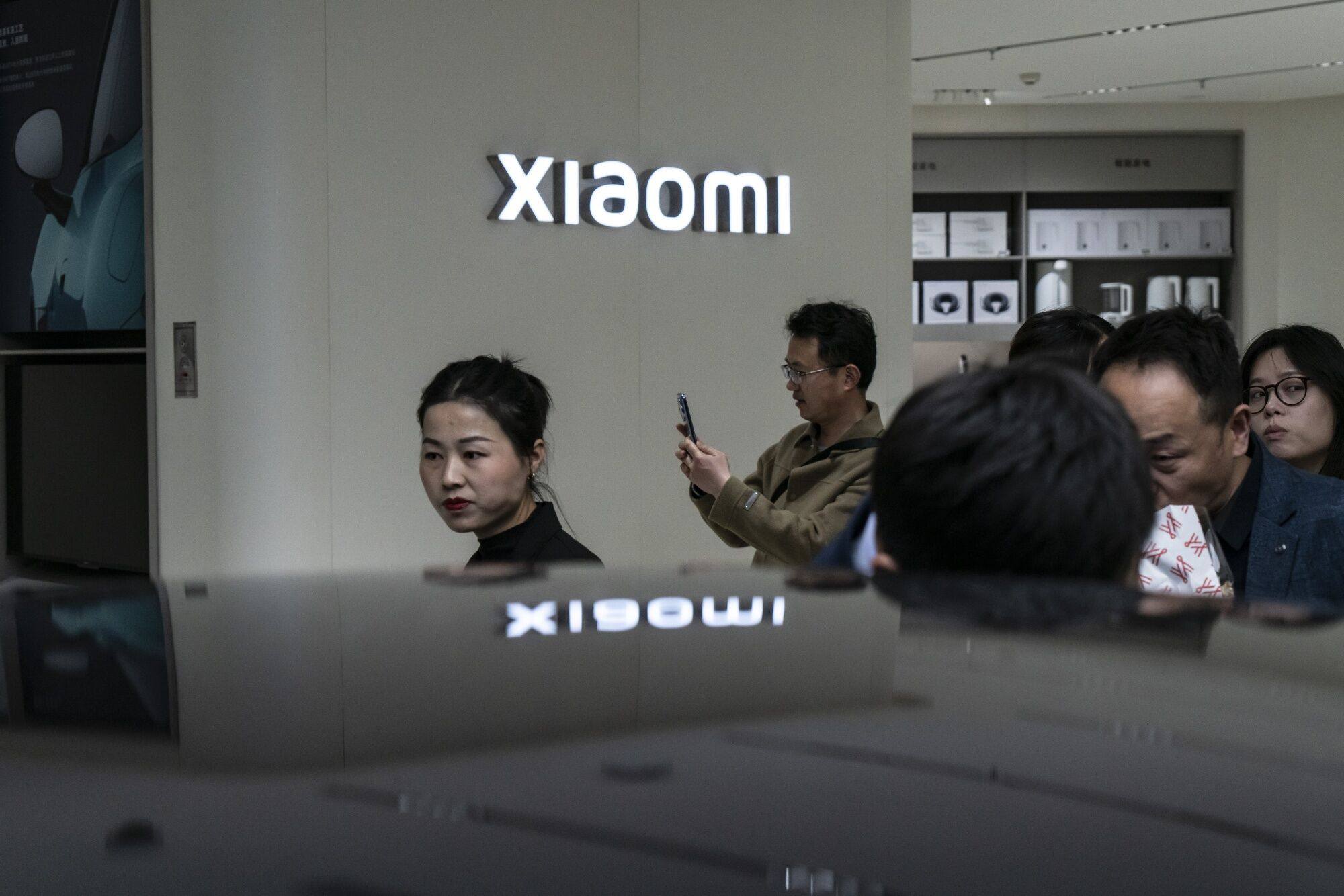 Customers look at a Xiaomi SU7 electric vehicle on display at one of the company’s stores in Shanghai, April 2, 2024. Photo: Bloomberg