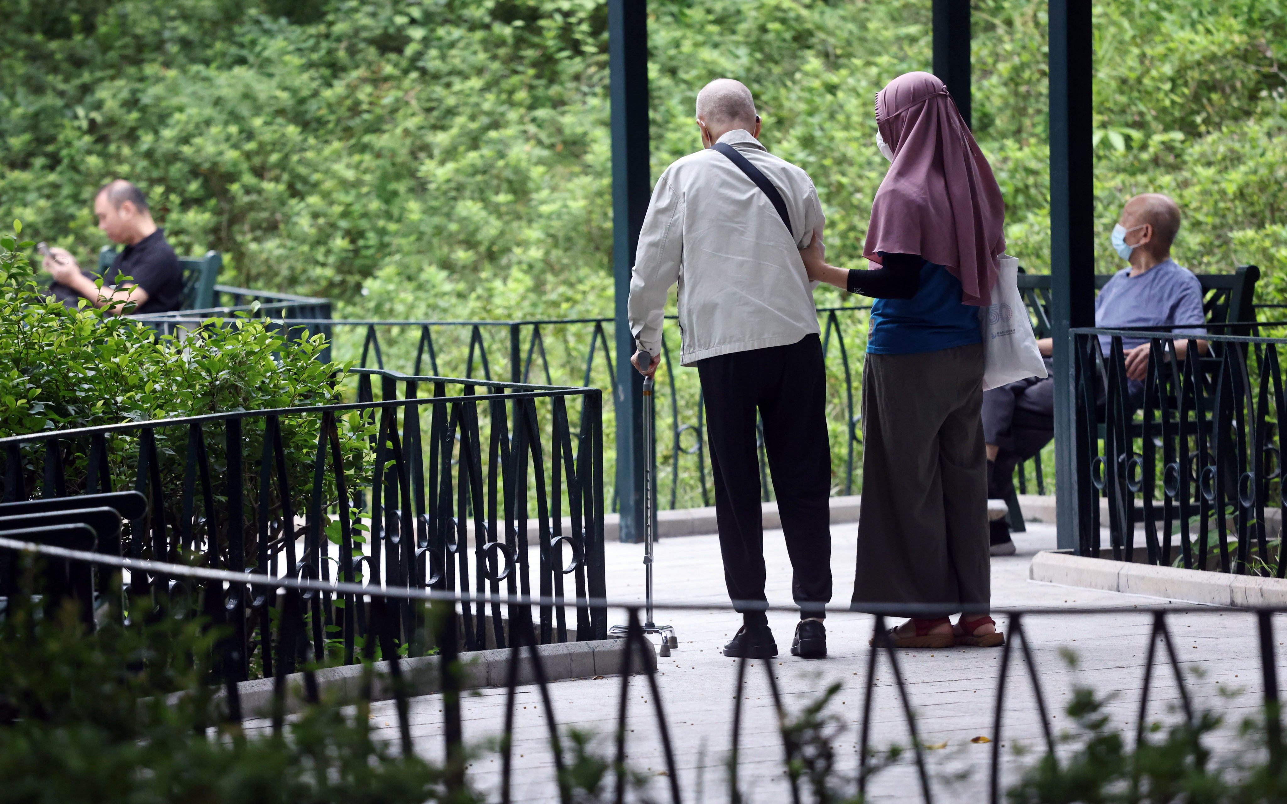 A foreign domestic worker with an elderly man at a park in Jordan in October 2022. Photo: K.Y. Cheng