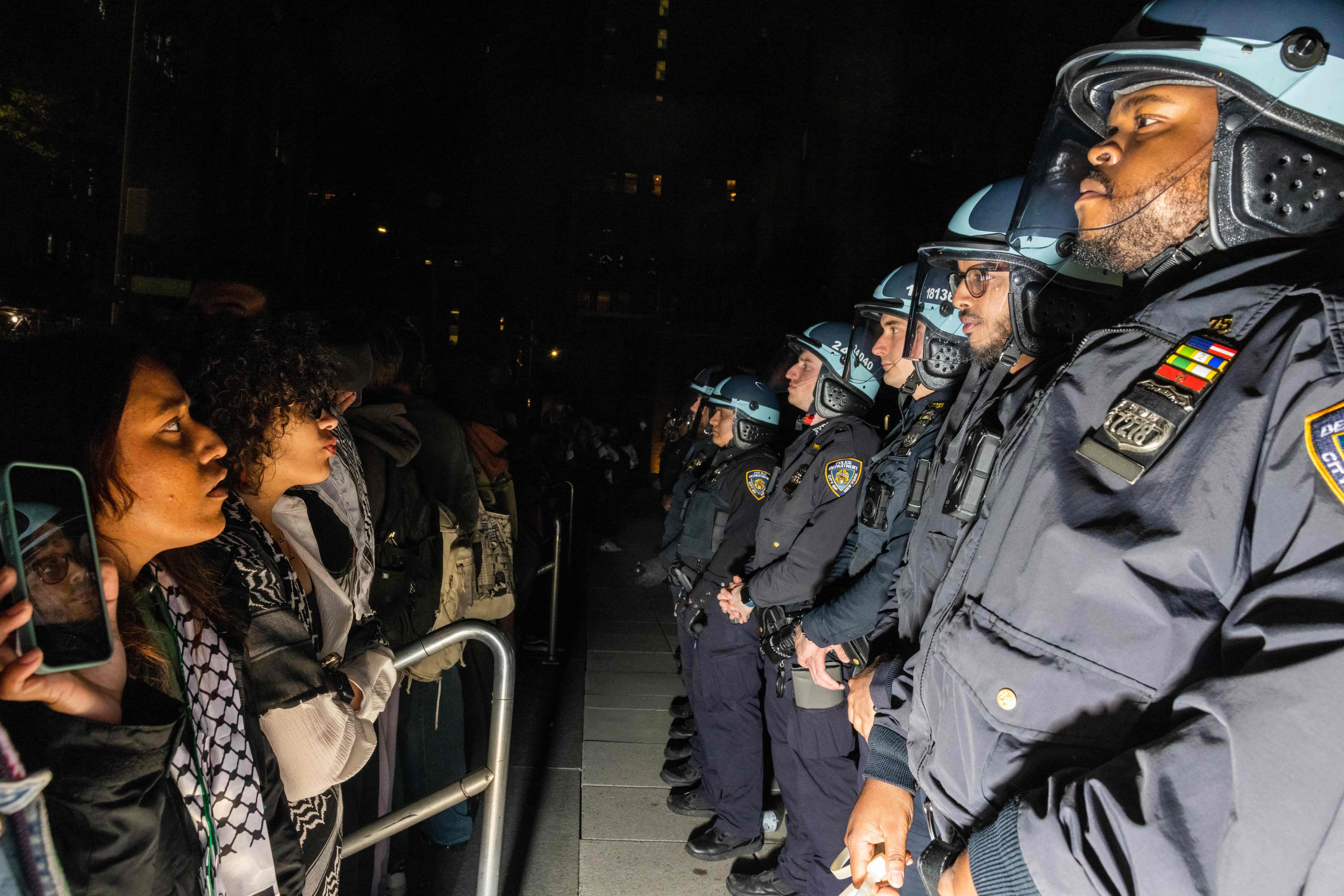 Pro-Palestinian students and activists face police officers on the New York University campus on Monday. Photo: AFP 