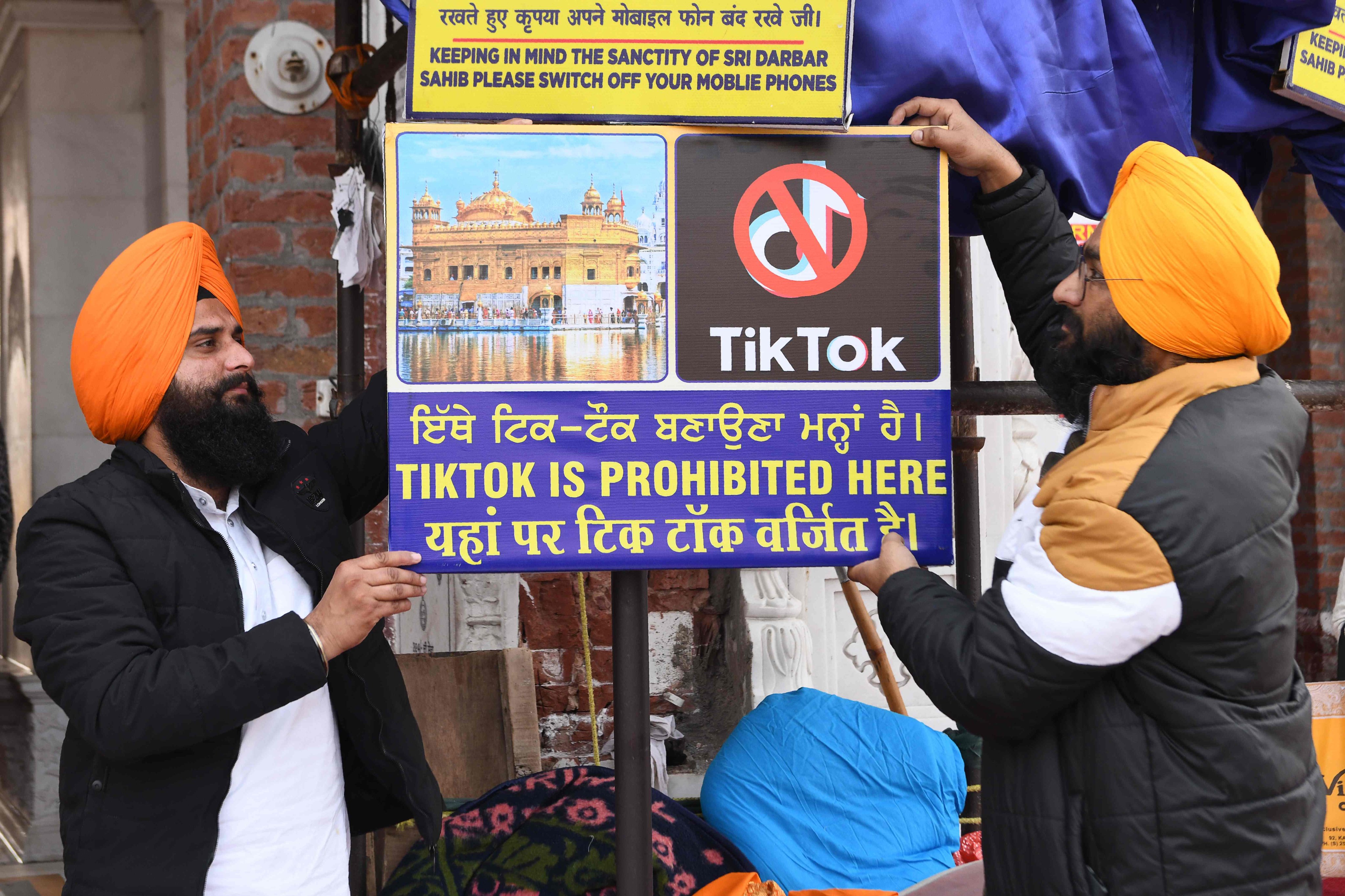 Sikh volunteers hang a sign reading ‘Tiktok is prohibited here’, at the Golden Temple in Amritsar. Photo: AFP/File