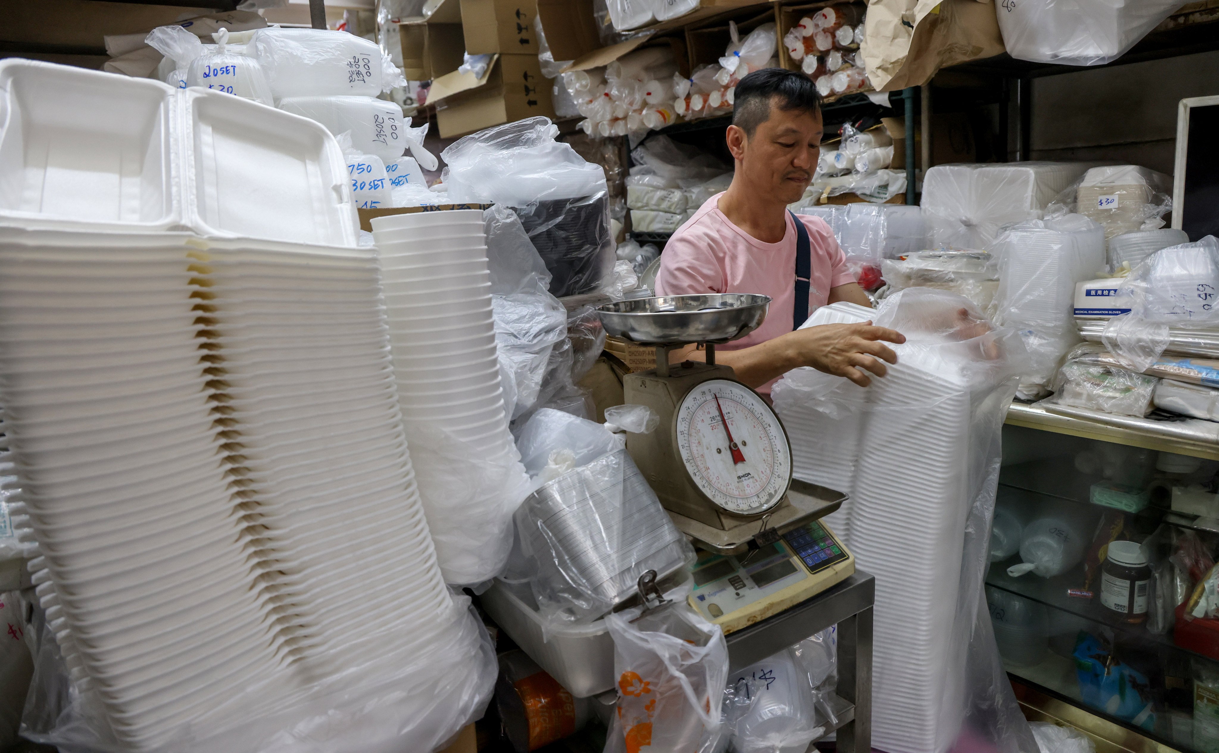 Dargon Cheung Kin-lung, owner of plastic tableware seller Luen Fat Plastic Bags in Sham Shui Po, handled his stock before a citywide ban on throwaway single-use plastics took effect. Photo: Dickson Lee
