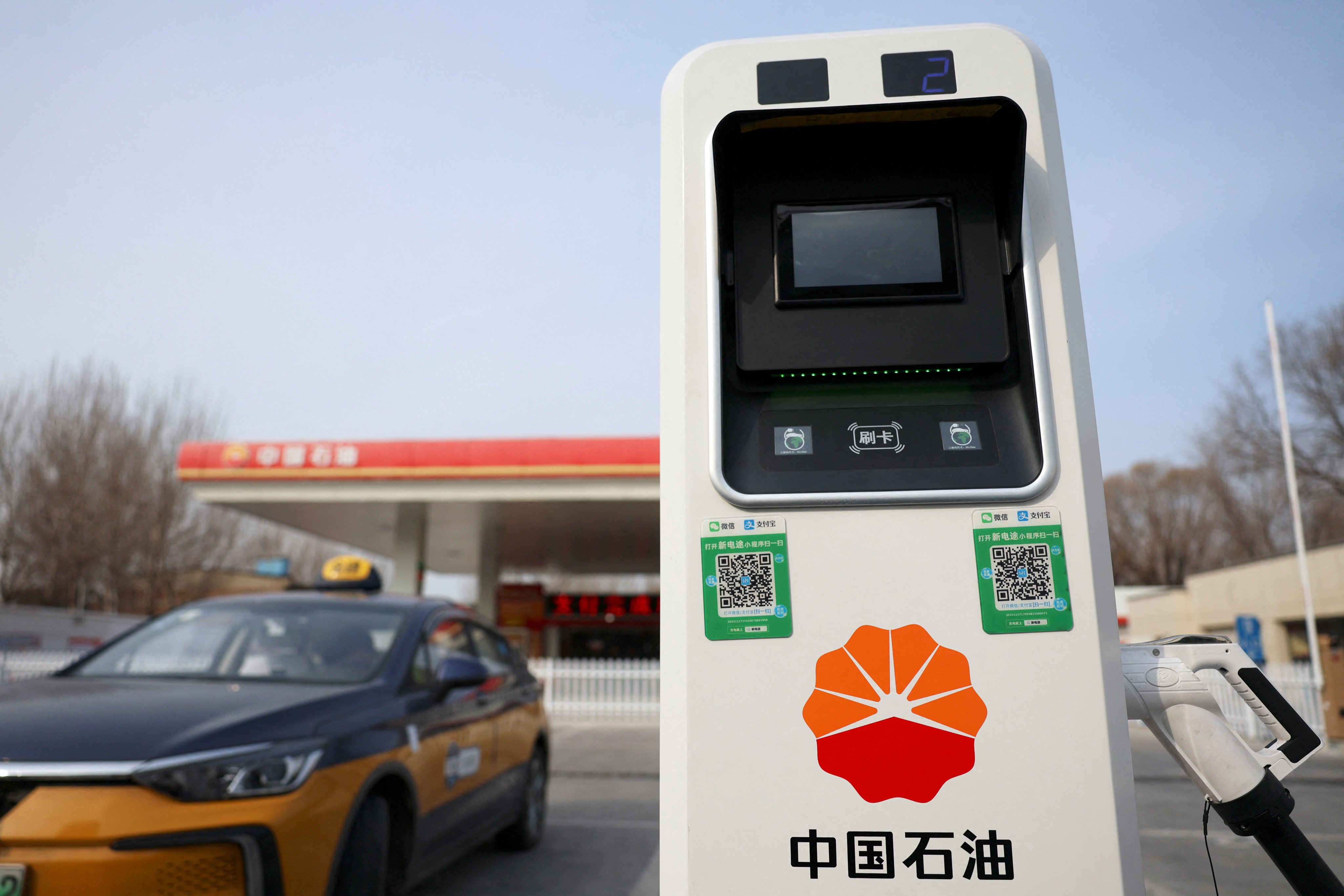 A PetroChina electric vehicle charging station stands next to one of its petrol stations in Beijing on February 2, 2024. Photo: Reuters