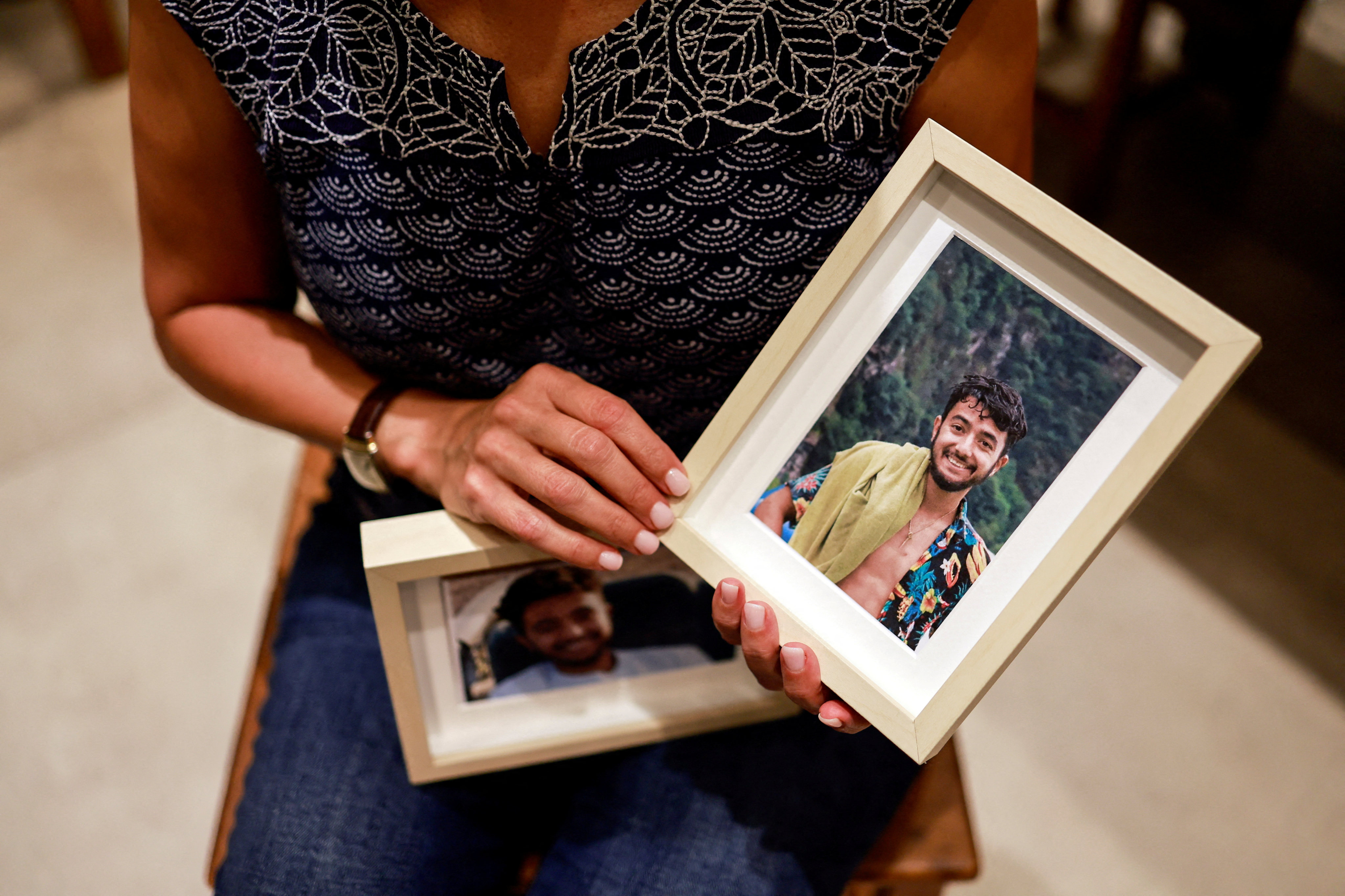 Rachel Goldberg, mother of Hersh Goldberg-Polin, holds photos of her son in their home in Jerusalem in October 2023. Photo: Reuters