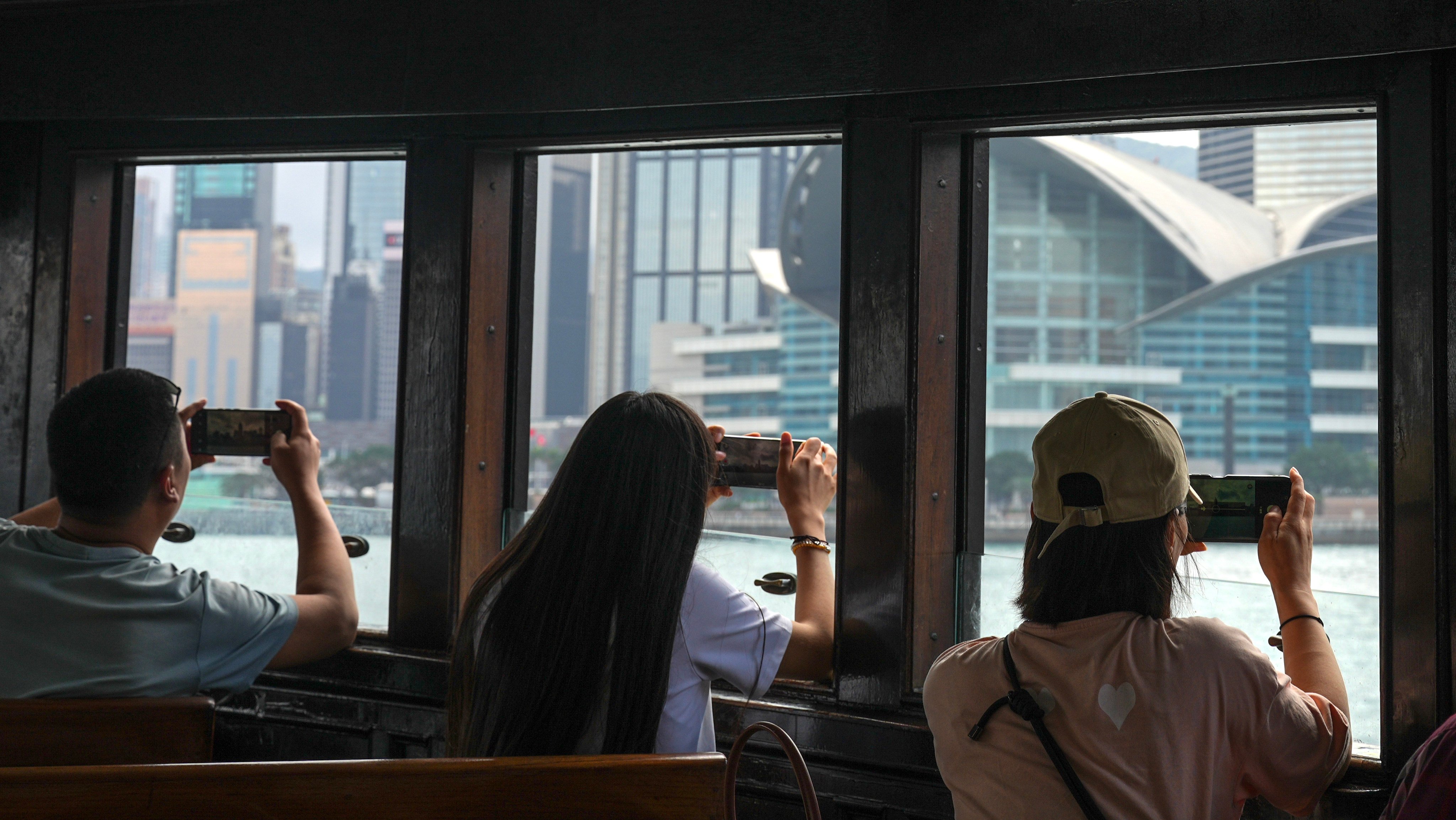 Tourists on the Star Ferry take photos of Victoria Harbour on February 24. Photo: Eugene Lee