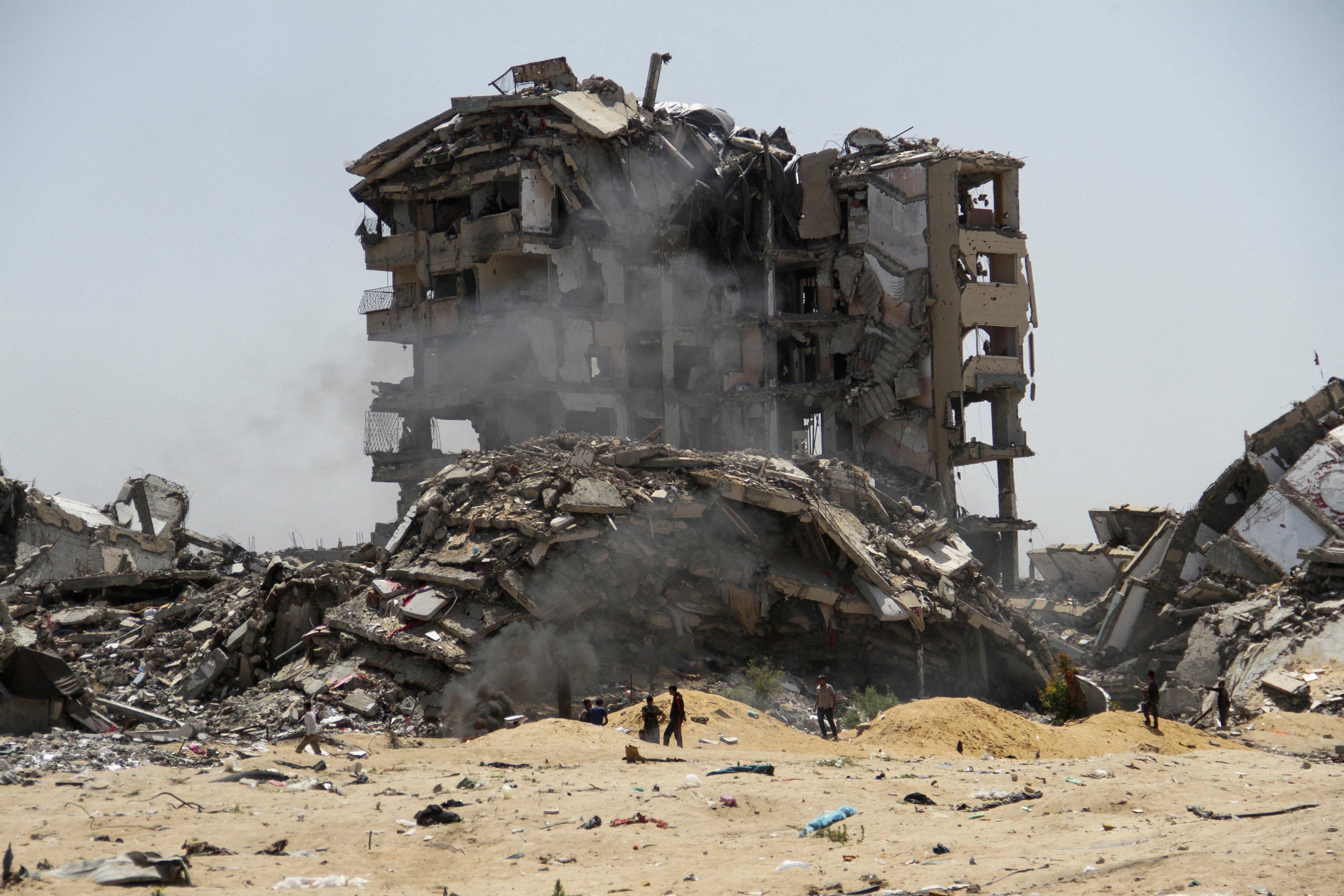 Palestinians walk past the rubble of residential buildings destroyed by Israeli strikes in the northern Gaza Strip on Monday. Photo: Reuters