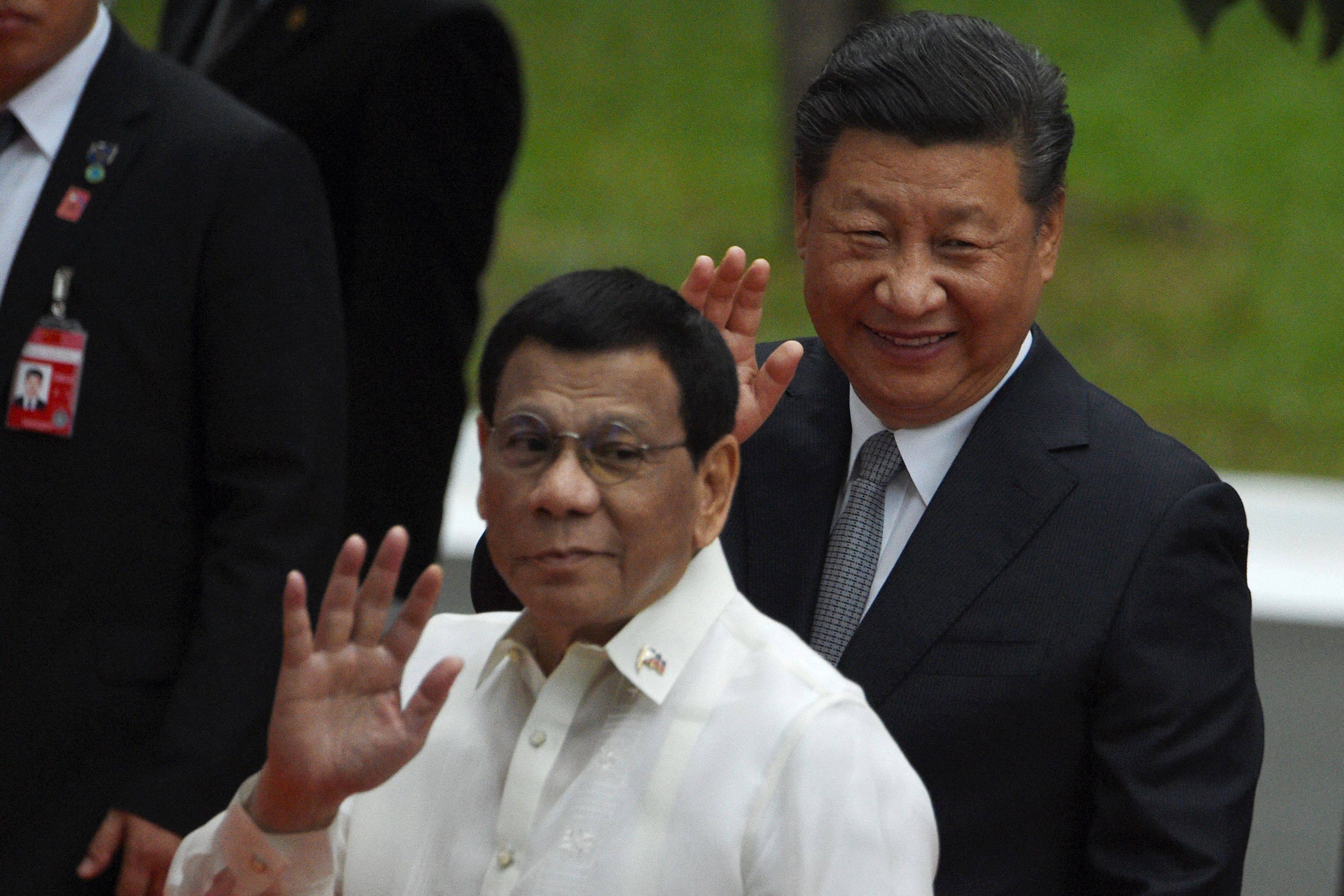 China’s President Xi Jinping (R) and Philippines’ President Rodrigo Duterte waving to members of the media in Manila on November 20, 2018. Photo AFP
