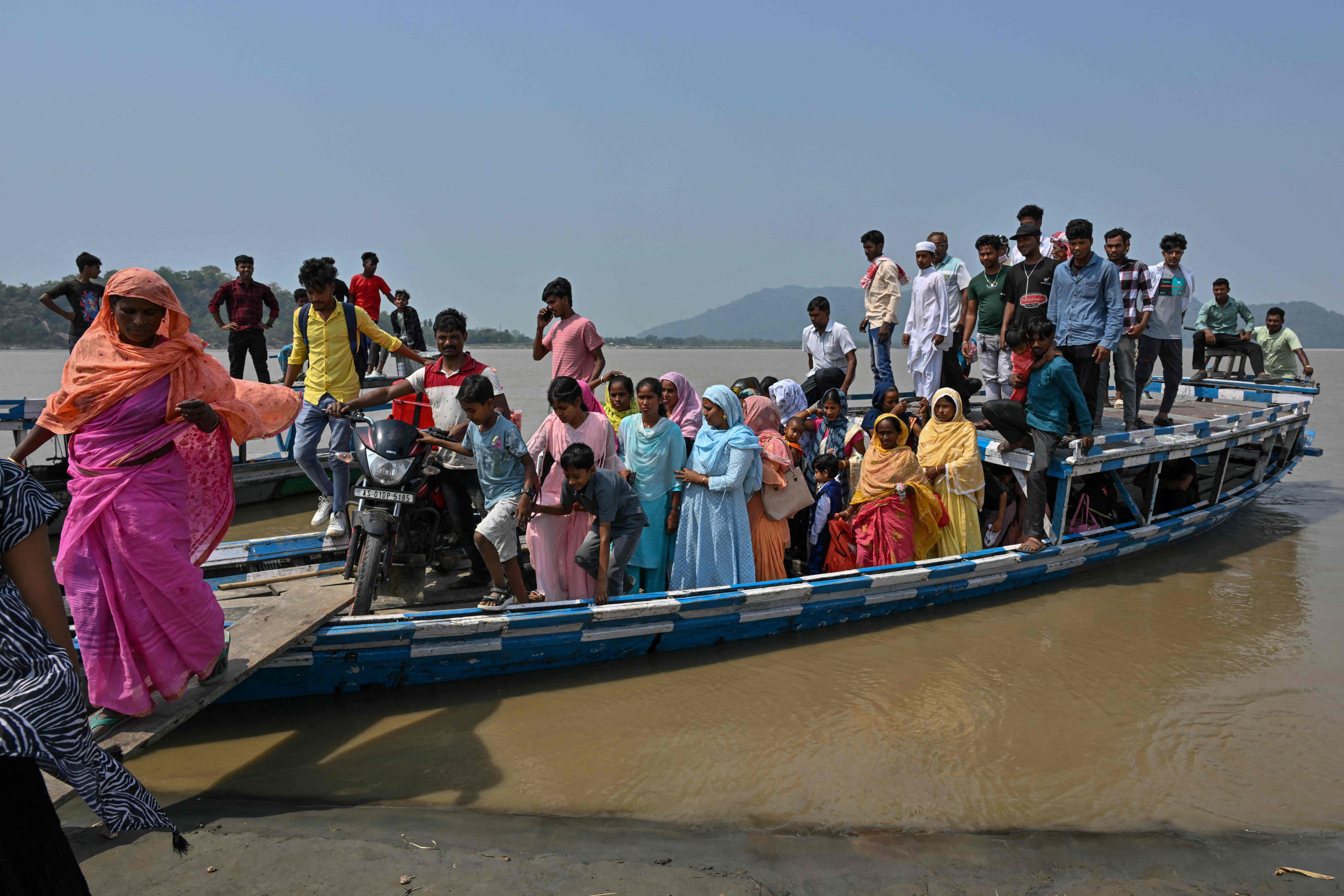 People travel on a boat to cast their ballot near a polling station during India’s general election in Assam state on April 26. Photo: AFP
