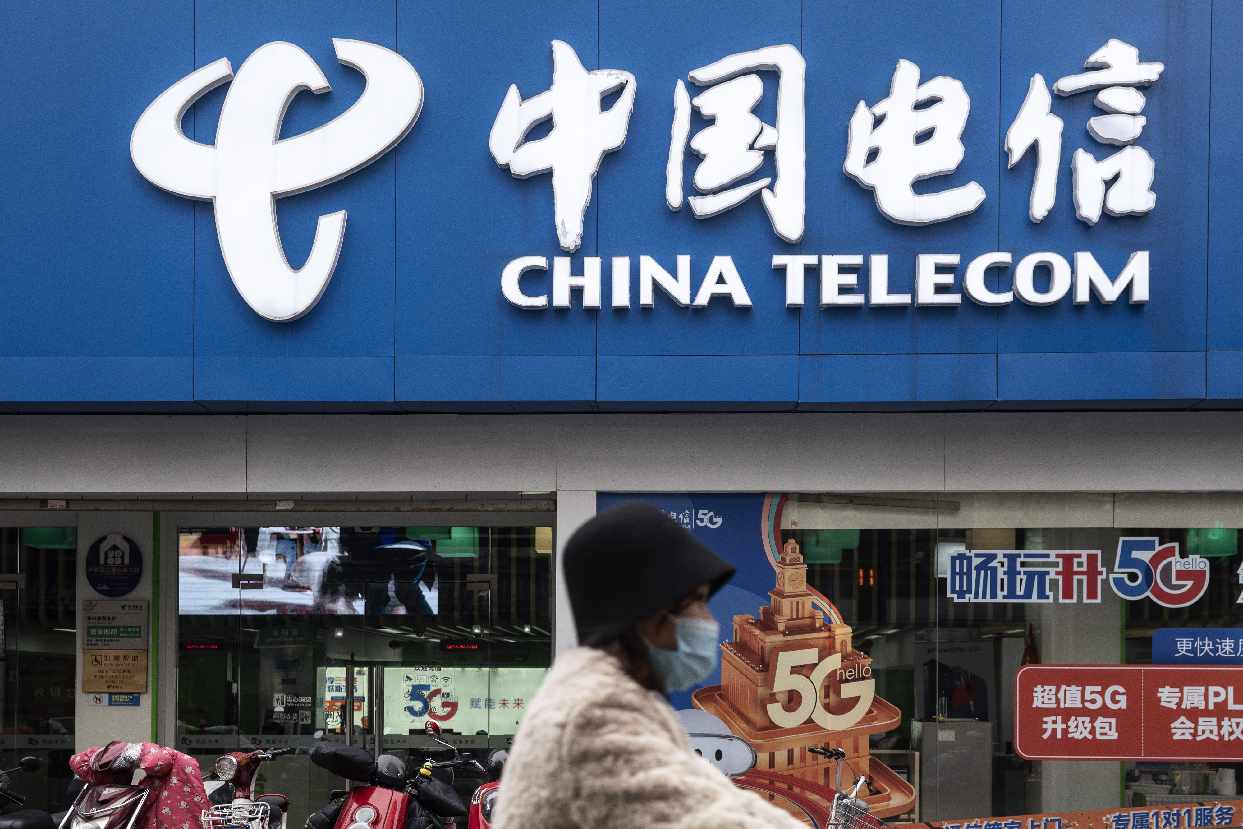 A motorist rides past a China Telecom store in Shanghai in January 2021. Photo: Bloomberg