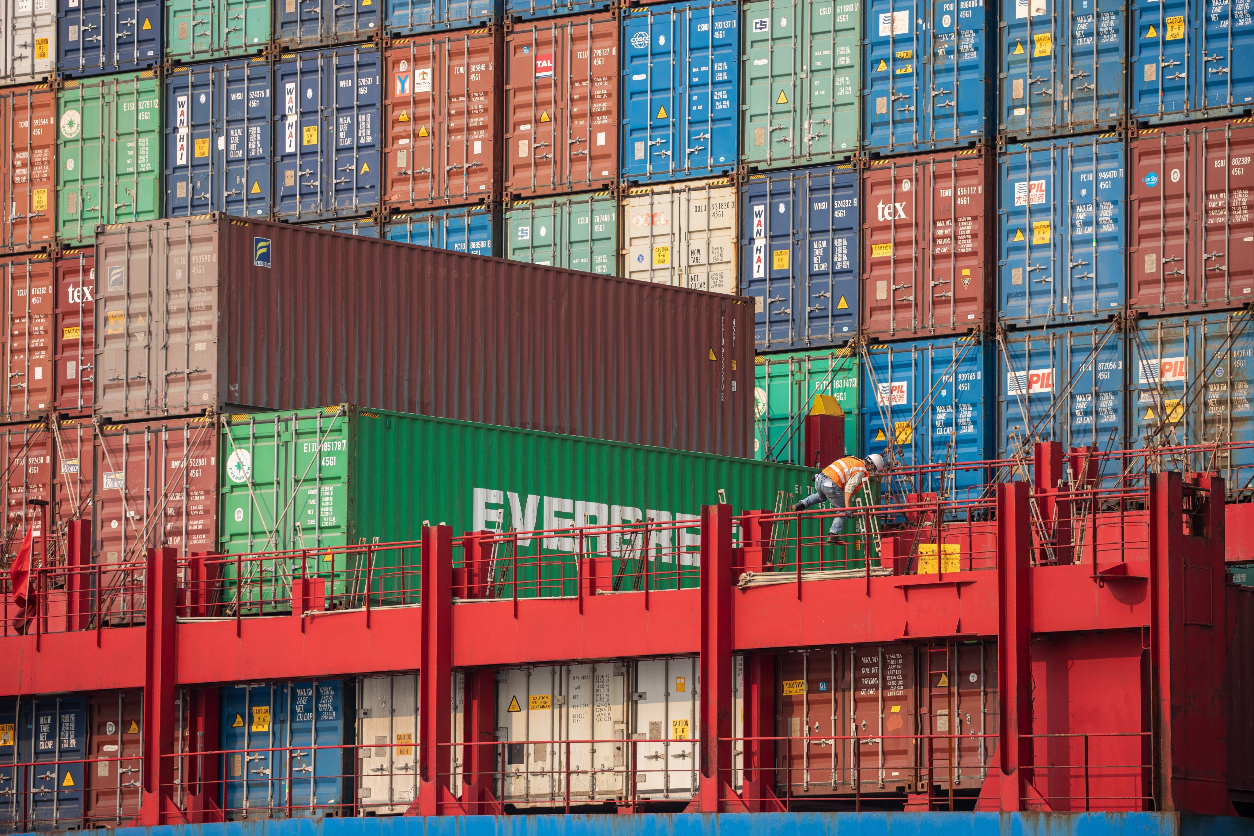 A worker secures stacked containers on a ship in Hong Kong’s Kwai Tsing Terminals in March 2021. Photo: EPA-EFE