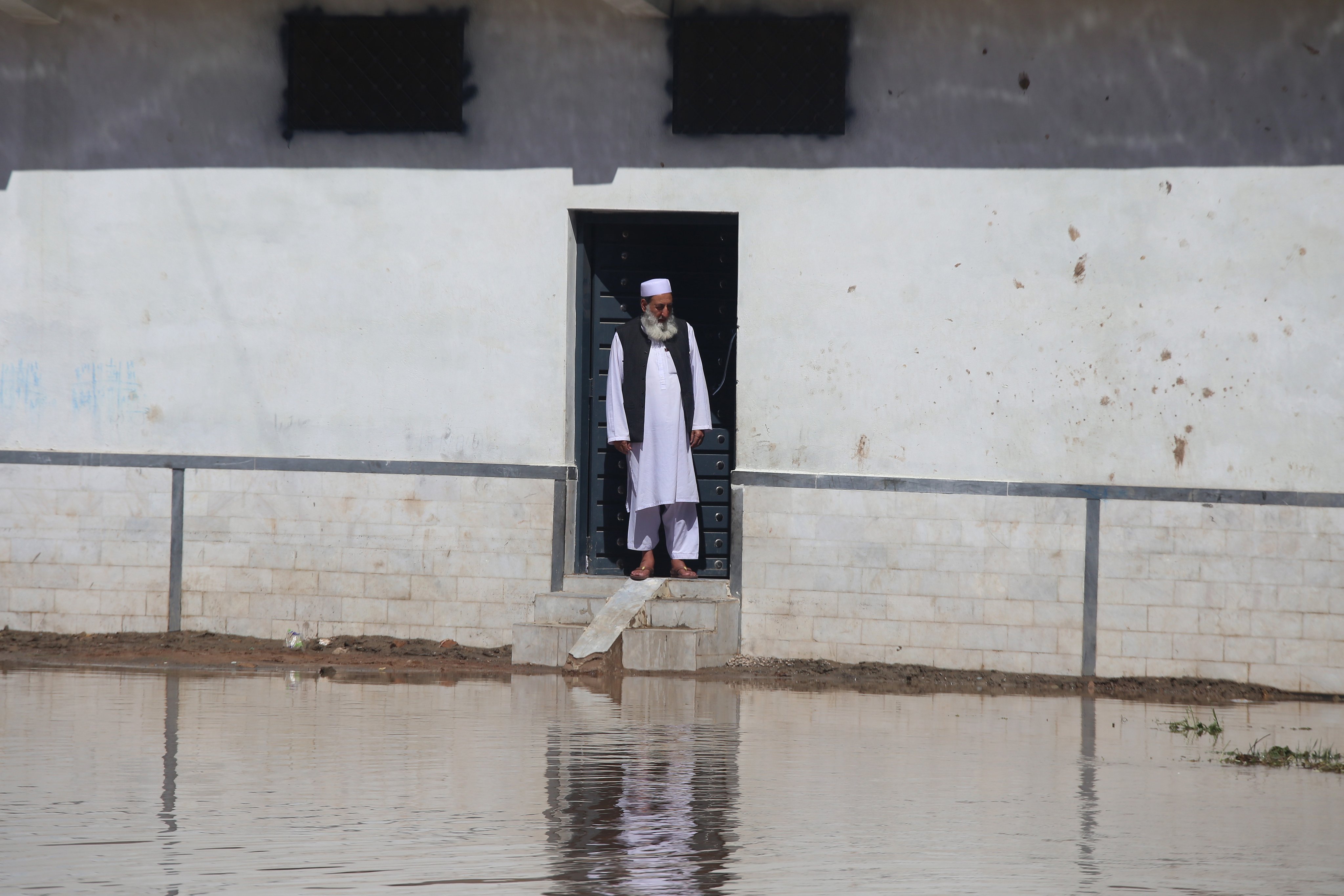 A man looks out of his home at a flooded street in Khyber Pakhtunkhwa province on April 16 as Pakistan floods again. The world is drowning in information amid challenges from climate change, geopolitical tensions, outright war, artificial intelligence and more. Photo: EPA-EFE