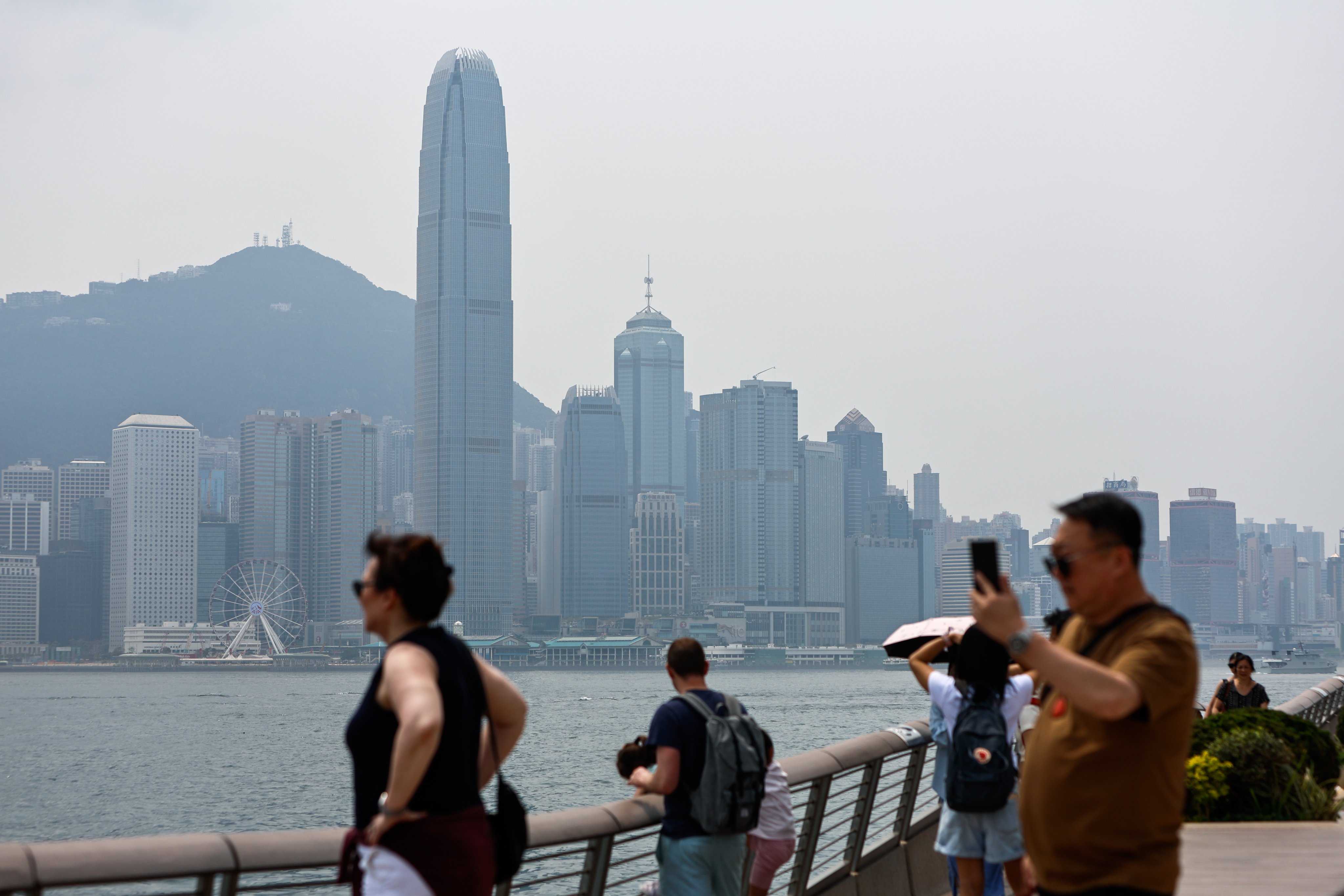 People enjoy the view by the Victoria Harbour overlooking Hong Kong’s Central Business District on March 29, 2024. Photo: EPA-EFE