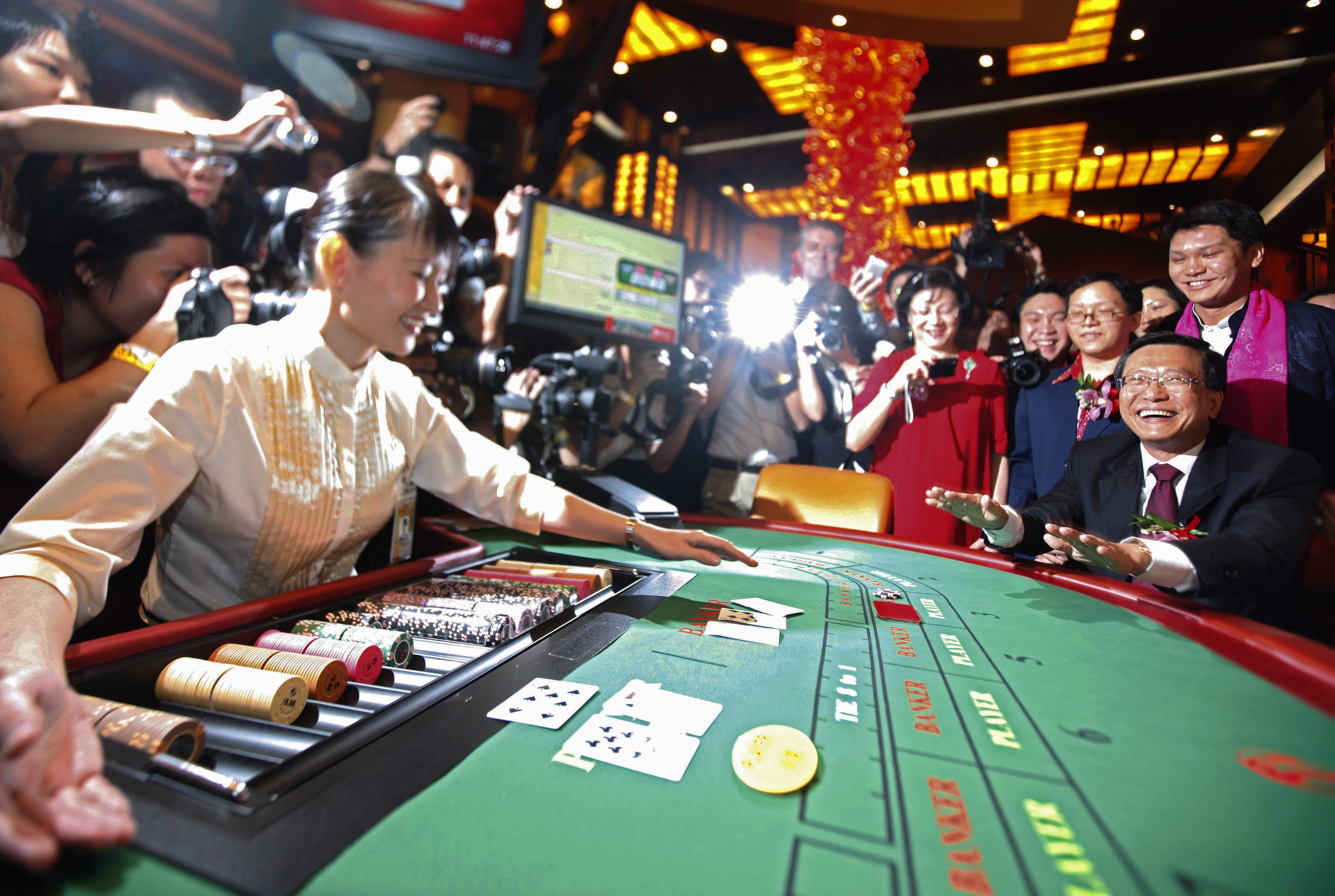 Chairman of Resorts World Sentosa and its developer, Malaysia’s Genting Group Lim Kok Thay plays baccarat to begin the soft opening of Singapore’s first casino in 2010. Photo: EPA-EFE